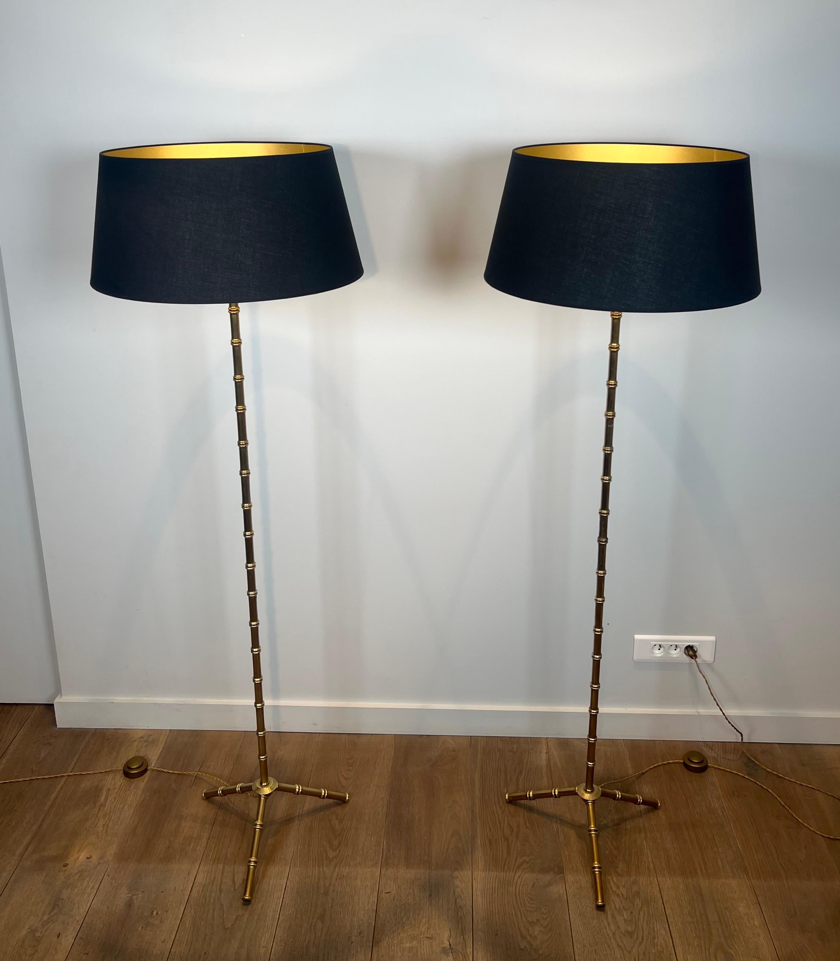 Questa rara e bellissima coppia di lampade da terra in finto bambù è realizzata in bronzo e ottone. Si tratta di un'opera francese del famoso designer Jacques Adnet.  Circa 1940