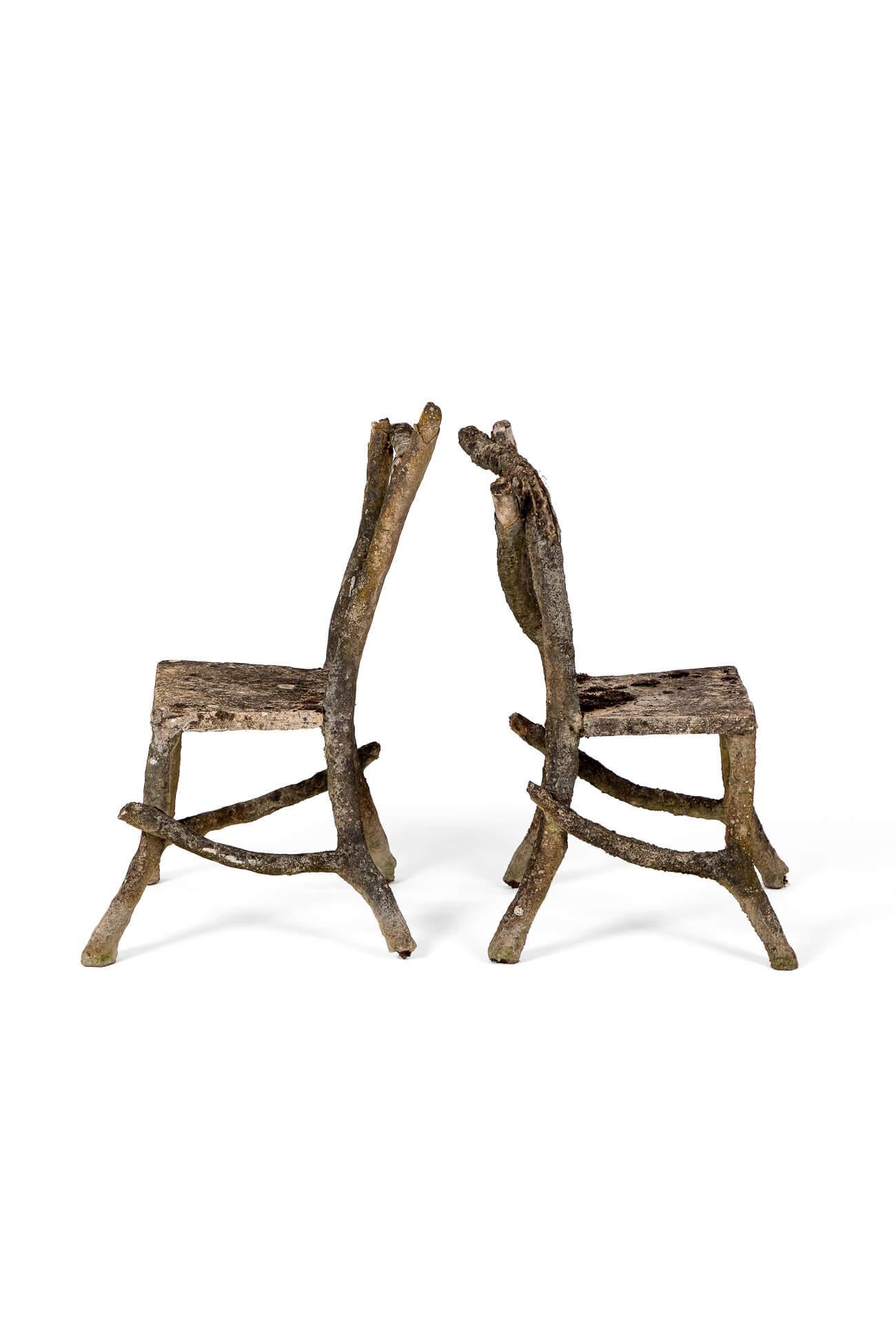 Un maravilloso par de sillas de jardín de Faux Bois con detalles de follaje y ramas.

Cada asiento muestra un respaldo alto con patas ensanchadas y diagonales de ramas alargadas.

Este par de sillas están hechas de piedra compuesta formada sobre una