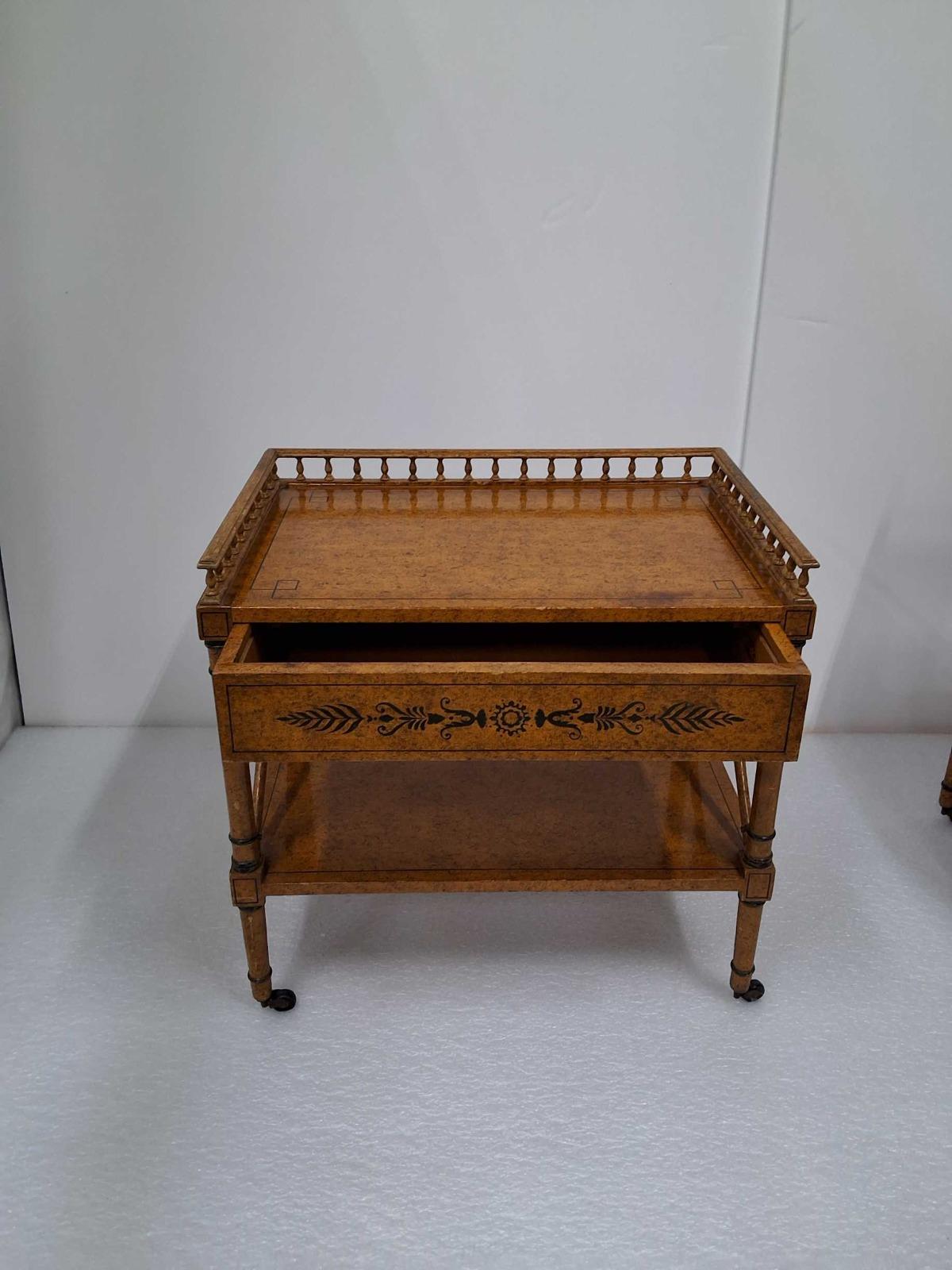 Beautifully crafted, wheeled, antique side tables from the 20th century. Finished with a faux-burlwood look and hand-painted details.