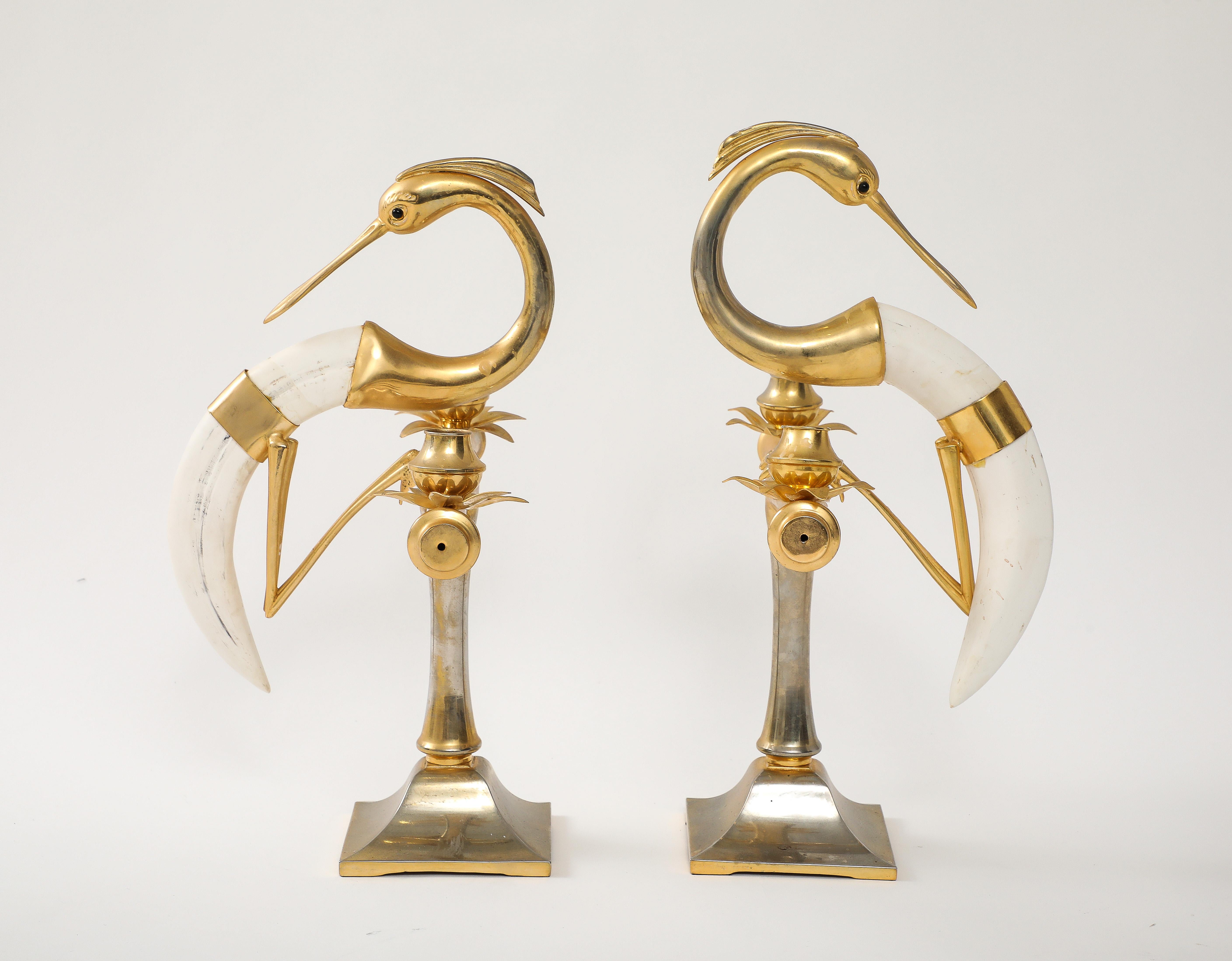 The two light pair of faux horn candelabra constructed of gilt metal and a resin horn all in the form of a figural crane, signed by Hauy Pouigo.

Base SIZE  4.75
