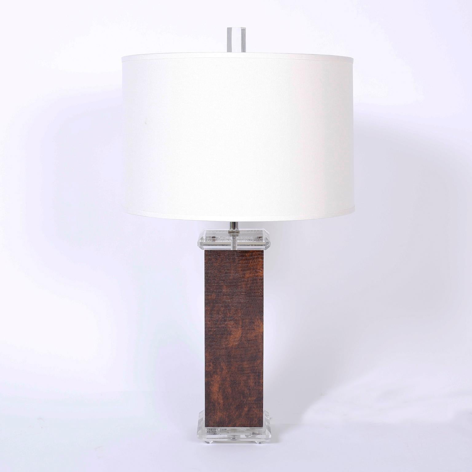 Pair of midcentury table lamps with an exotic mix of materials, having Lucite finials, caps, and feet. Featuring faux lizard wrapped rectangular bodies.