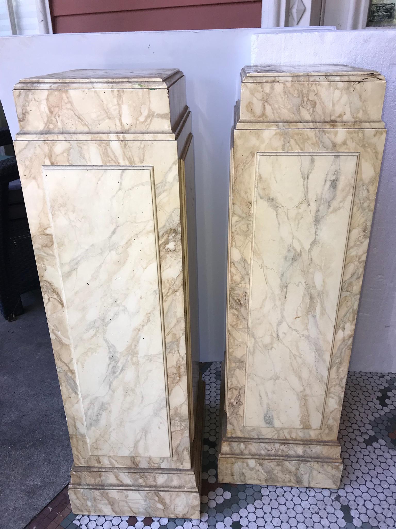 Midcentury pair of rectangular form of pedestals with a pale yellow faux marble 
Finish (simulating Sienna marble). Each pedestal bottom weighted so not to tip. Finished on all 4 sides with raised coffered panels and tapered tops. 

Minor wear,