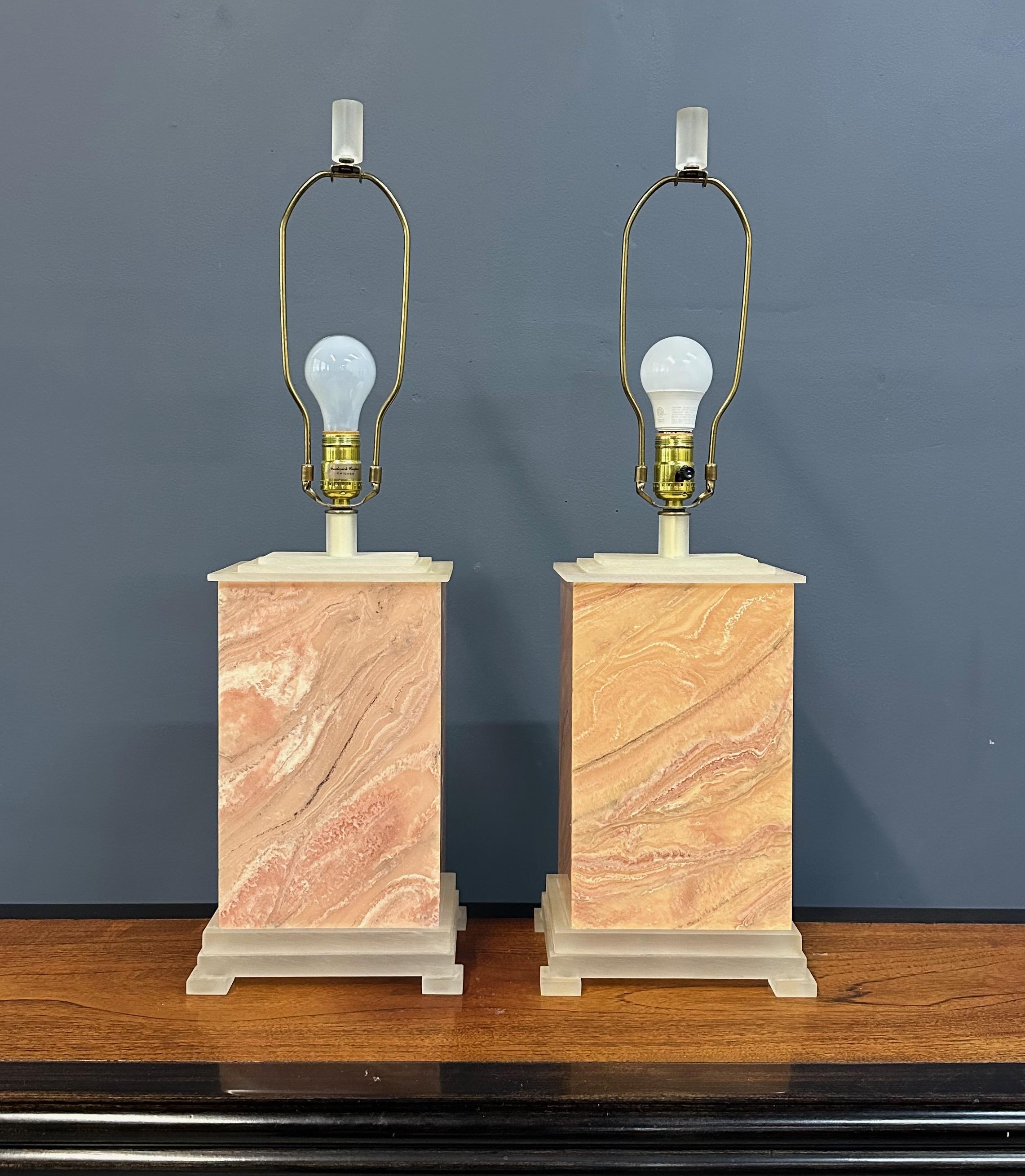A refined blend of postmodern geometry and classical influence, this pair of  table lamps by Frederick Cooper dates to 1990 and features richly veined faux marble finishes in warm terracotta tones. Resting on tiered plinth-style brushed acrylic