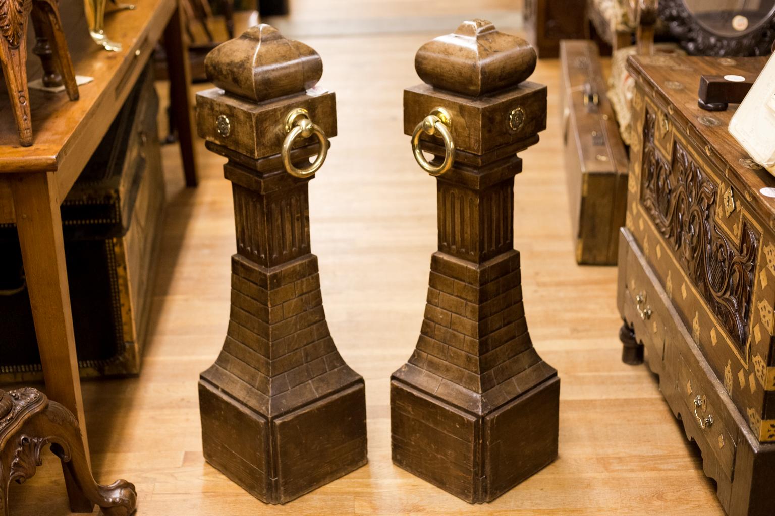 Pair of faux painted French pine opera bollards with the original large brass ring handles. Each has a fluted stem on a simulated architectural stonework pedestal.


   