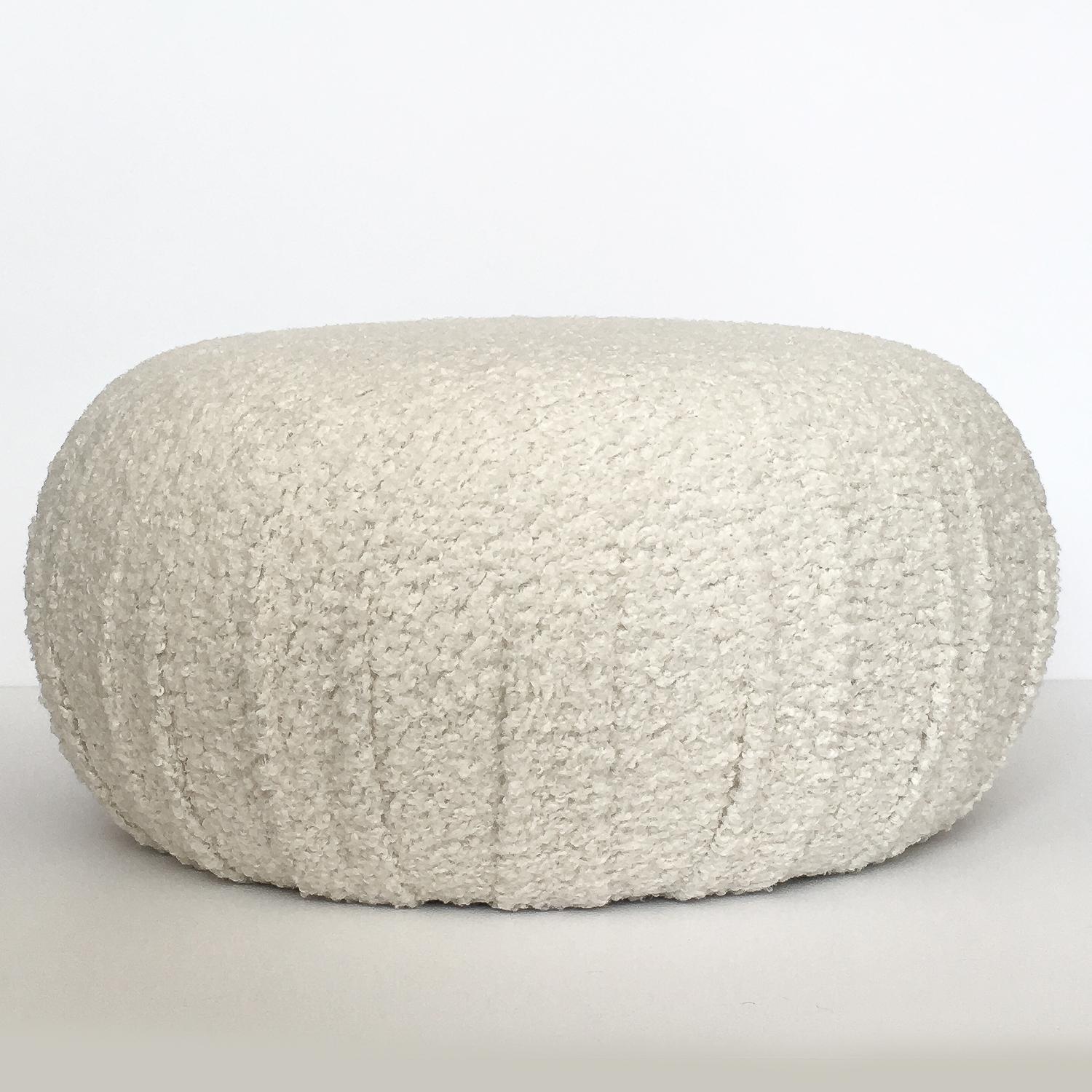 Pair of fully upholstered round souffle pouf ottomans. Newly constructed and upholstered in an off-white faux shearling / sheepskin with soft, curly, nubby texture. Excellent option for additional seating or foot stools. Fabric swatch available upon