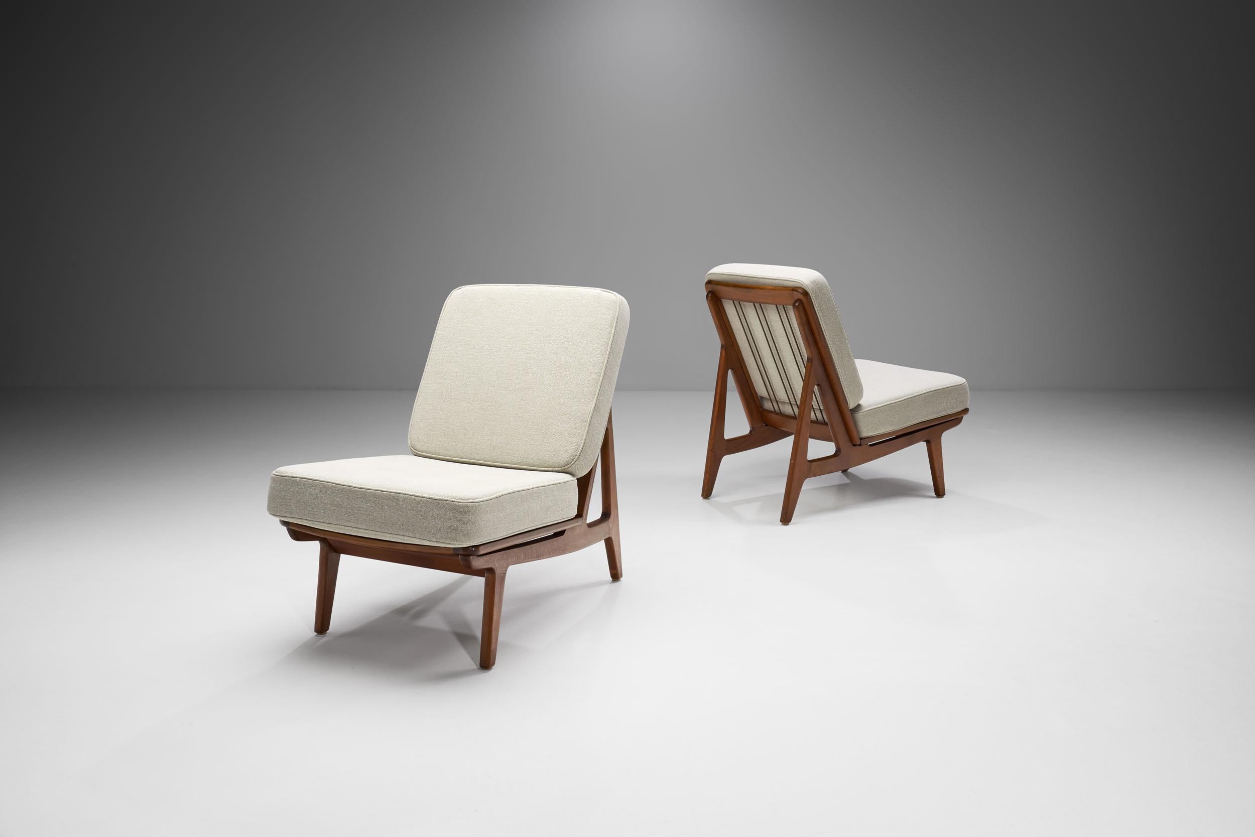This pair of beech “FD172” easy chairs was designed by the Danish designer duo, Peter Hvidt and Orla Mølgaard-Nielsen for the manufacturer France & Daverkosen in the 1950s.

This beautiful pair of slipper chairs feature a modest and elegant