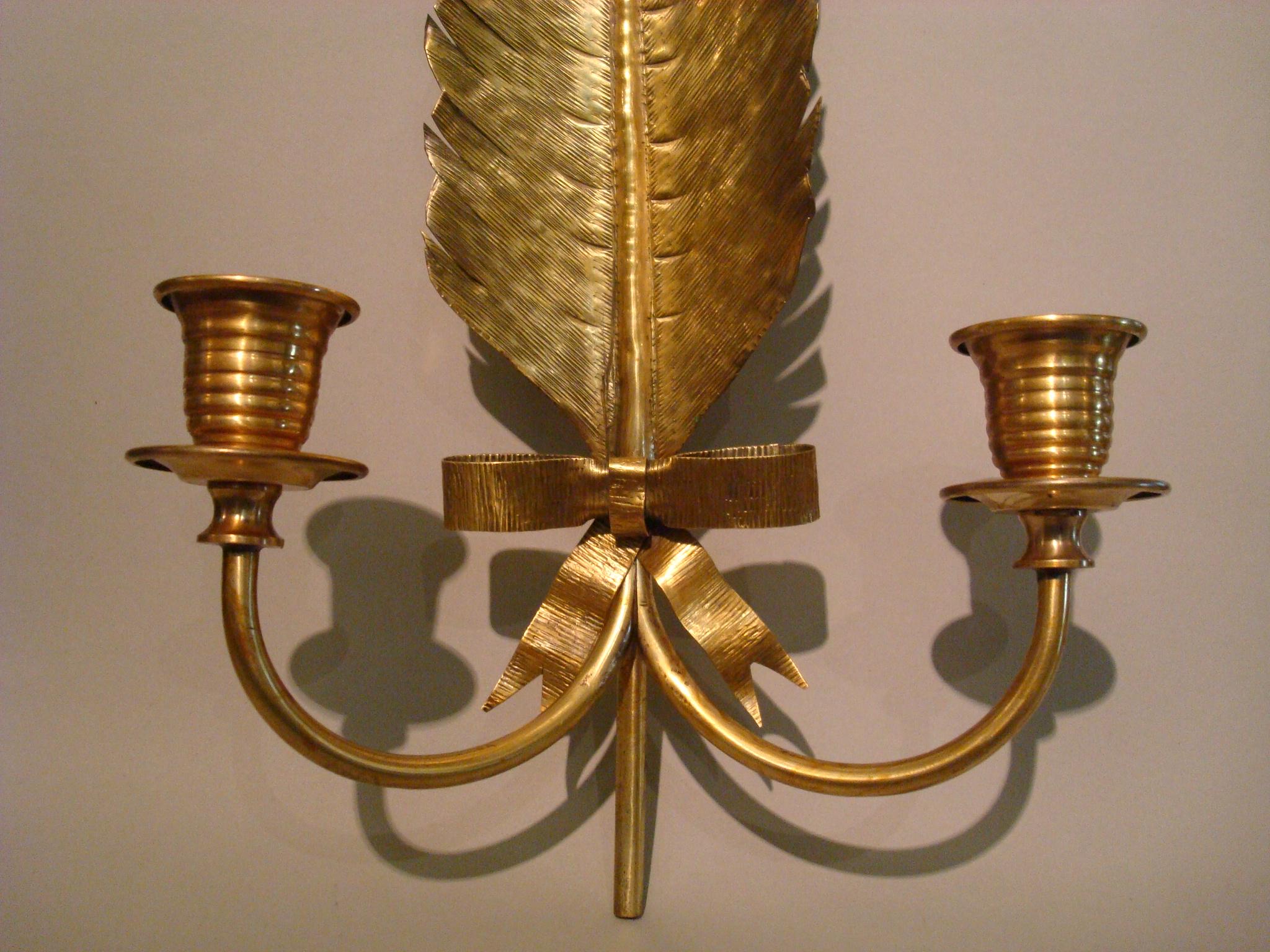 A stylish pair of gilt sconces attributed to Maison Jansen brass sconces in feather form with ribbons. Two lights. Original condition.