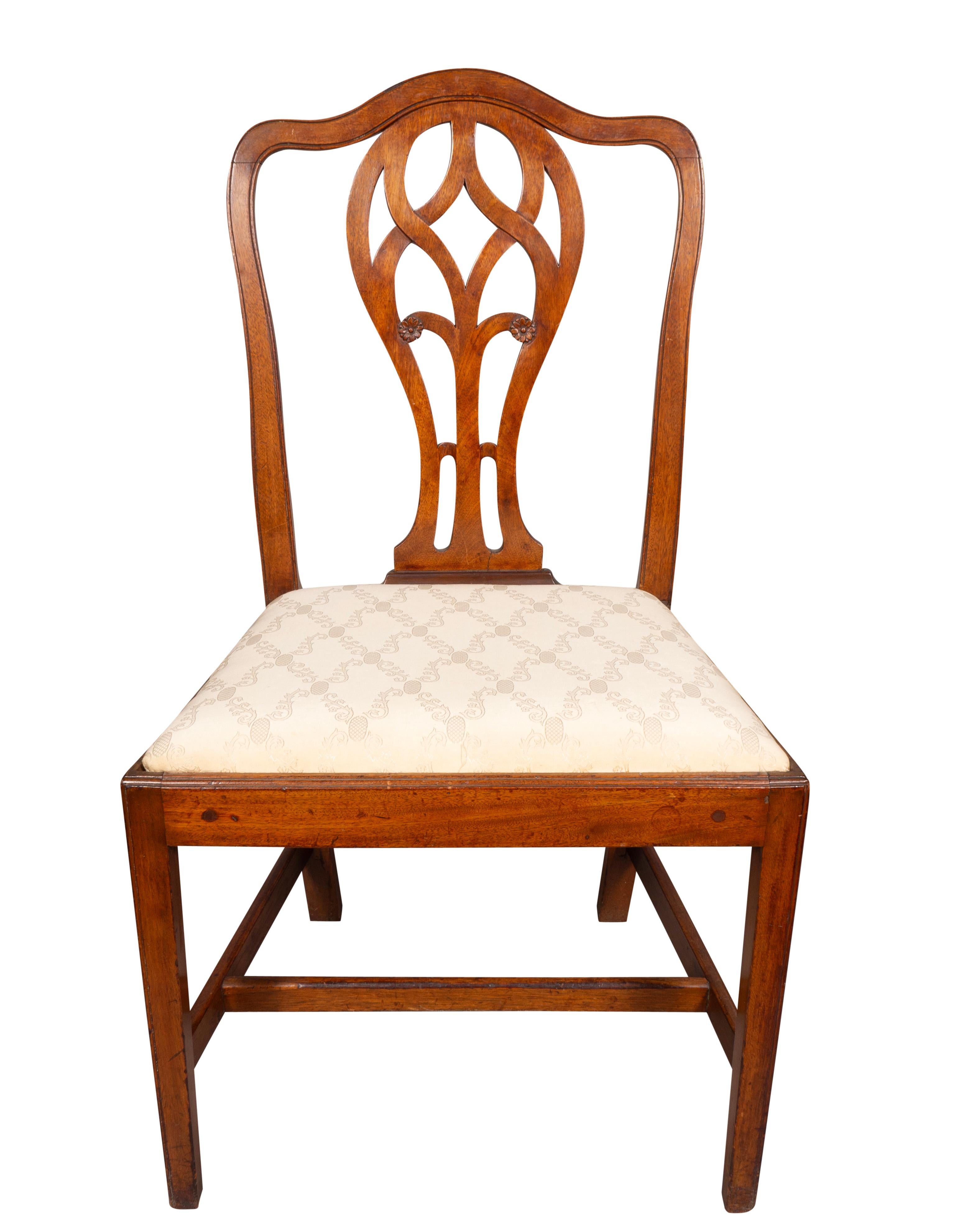 With arched backs with pierced splats with small carved rosettes. Drop in seats and raised on square tapered legs with H form stretchers.