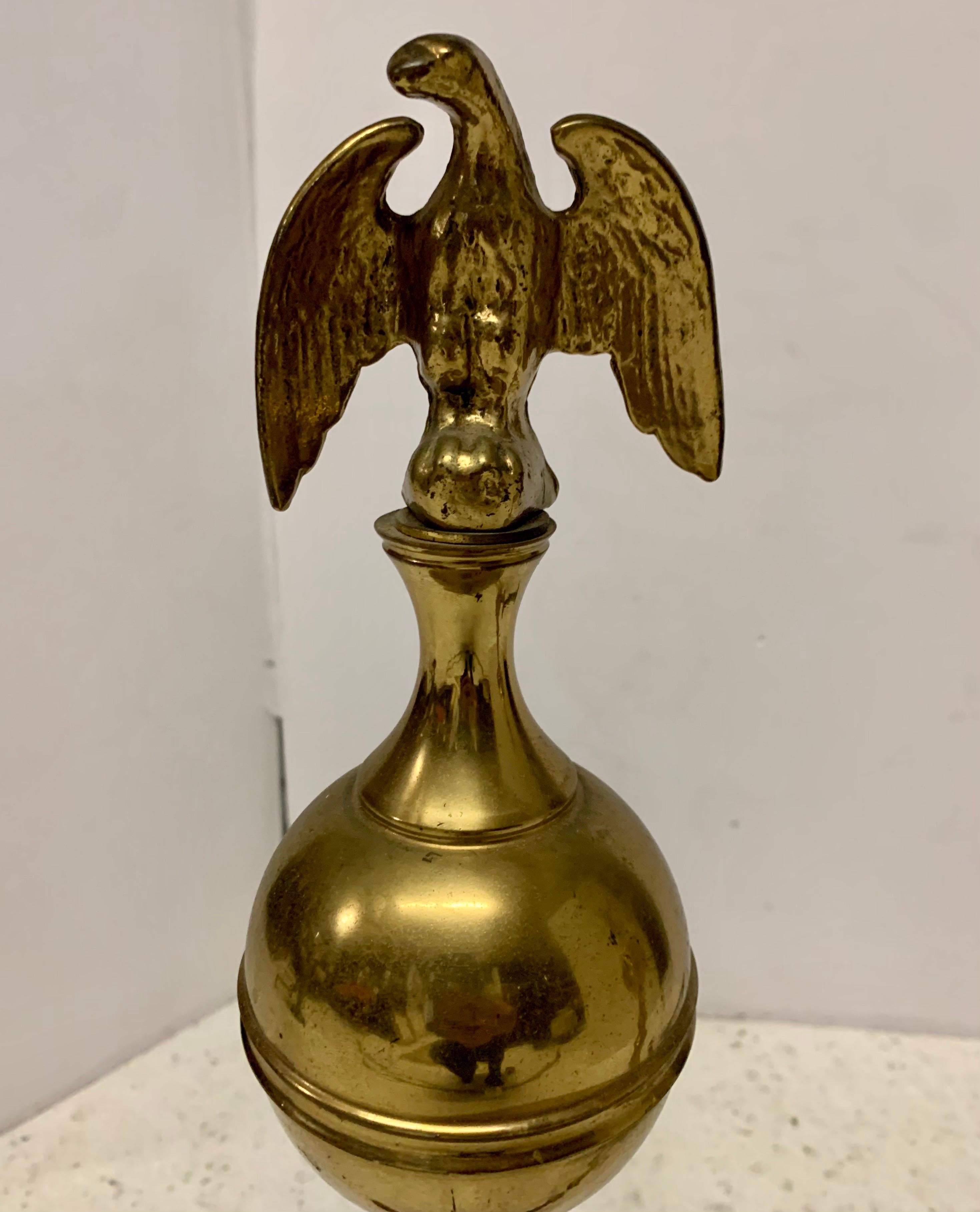 Federal style heavy brass andirons with eagle tops surmounted on brass cannonballs and supported on ball and claw feet.