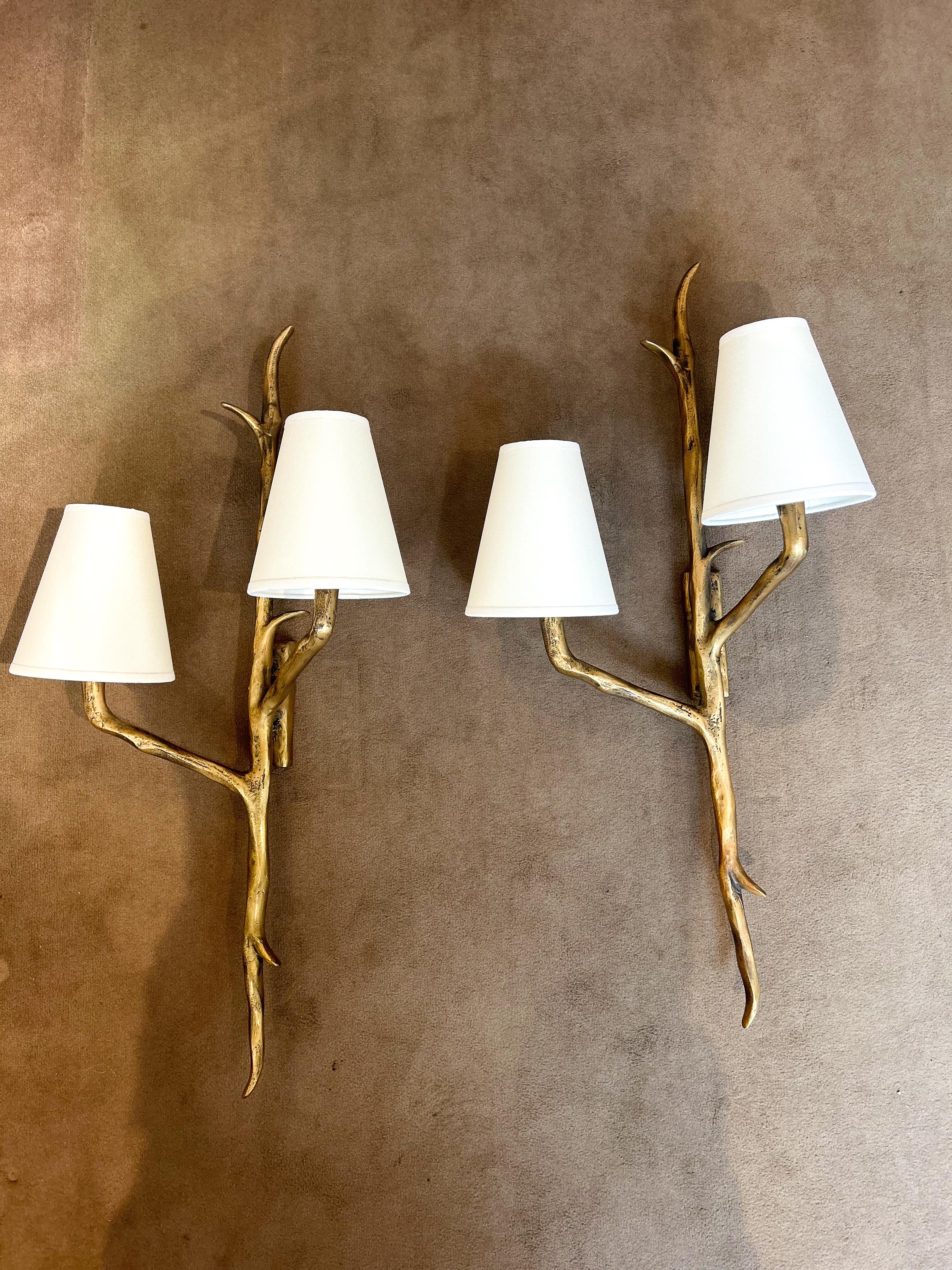 Exquisite pair of bronze sconces by the Maison Arlus in the style of Félix Agostini. This pair of sconces were created in France circa 1960. The lampshades are all new and were made specifically for this pair of sconces. 

The bronze sconces are in