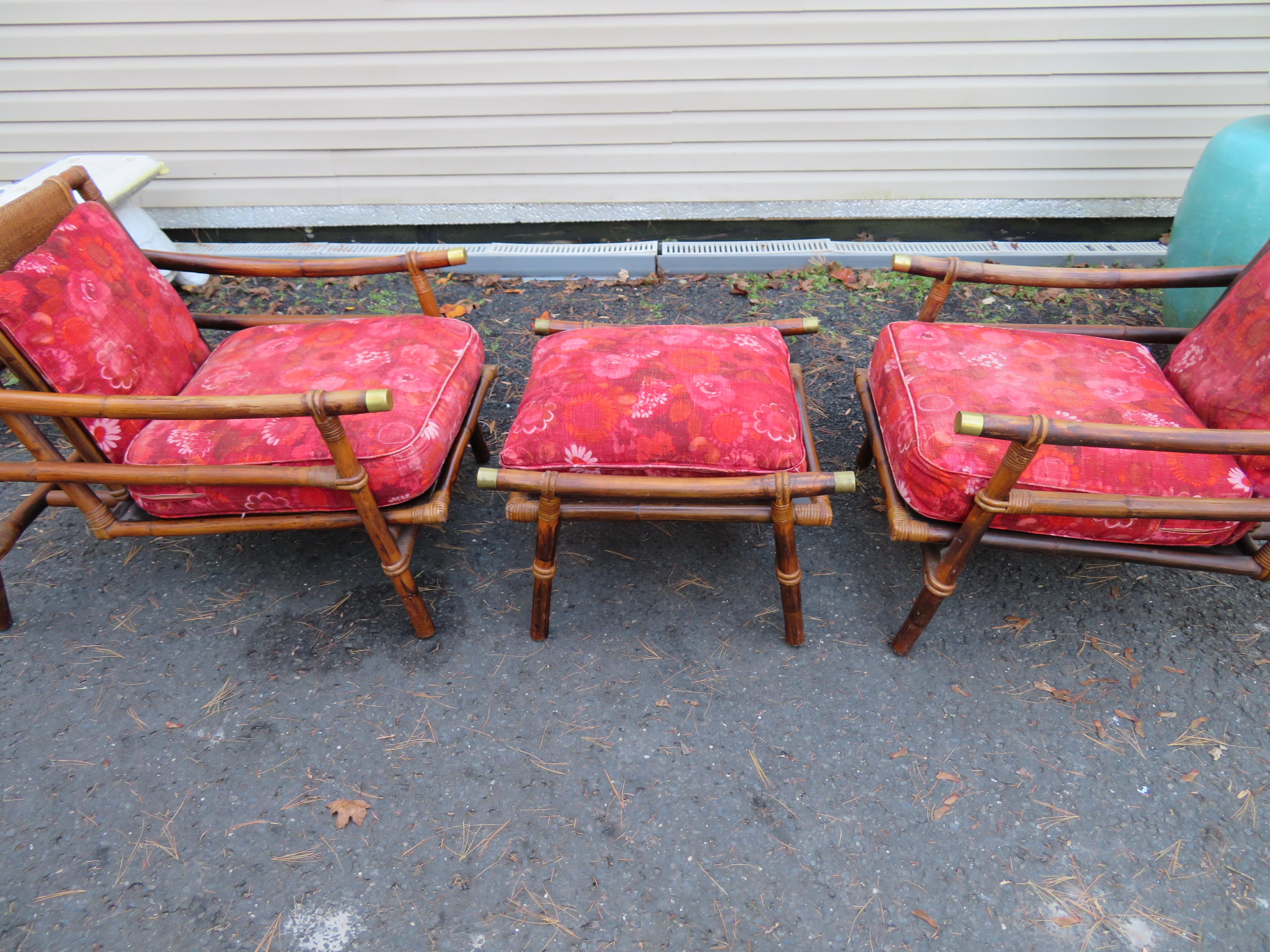 Jolie paire de fauteuils club ou de salon en rotin Ficks Reed de style Campagne, plus un ottoman avec d'intéressants accents en laiton par John Wisner pour la collection Far Horizons, 1954. Cette paire conserve sa finition sombre d'origine avec de