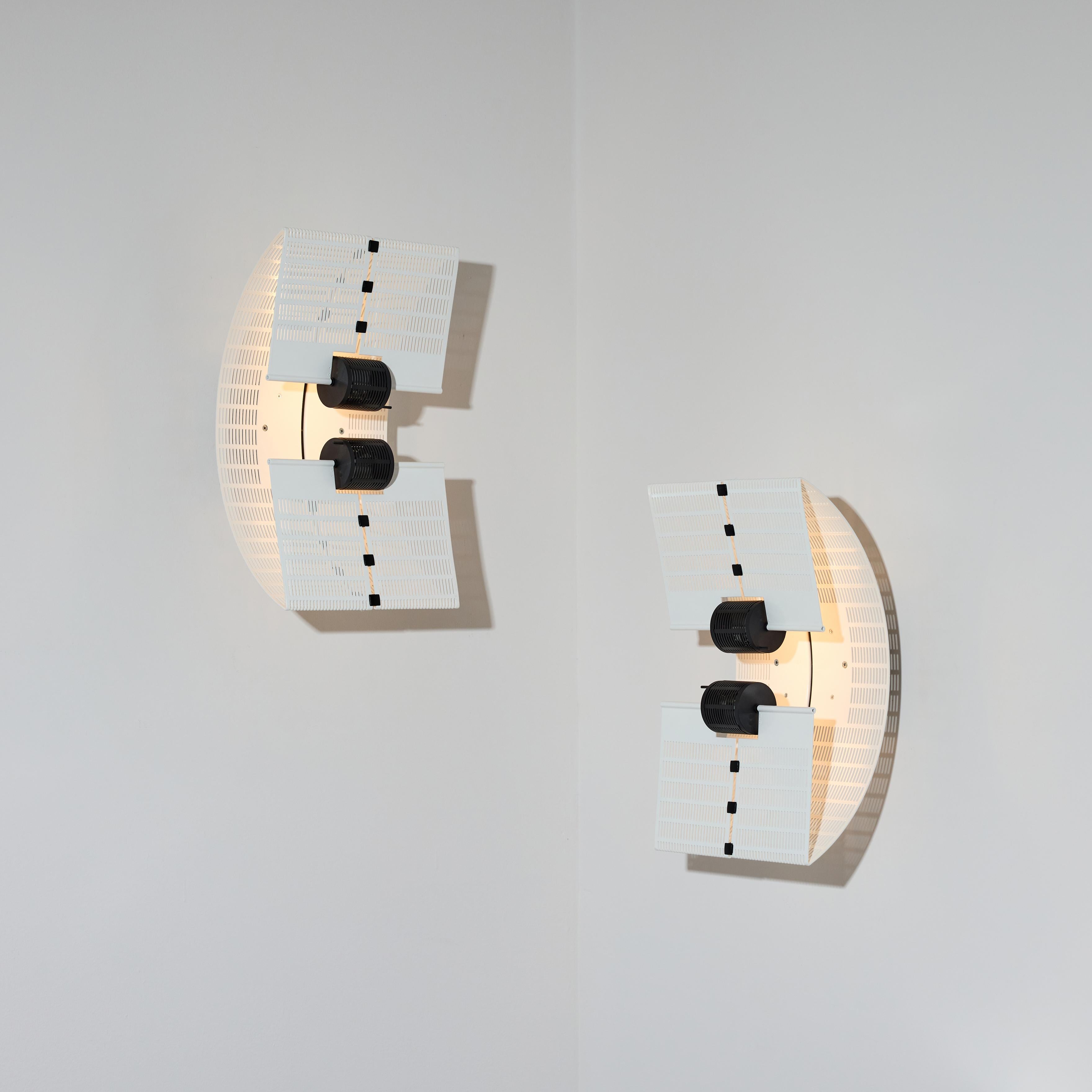 Coppia di rare applique Fidia di Mario Botta. Progettato e prodotto in Italia, nel 1985. Metallo verniciato a polvere di colore bianco e accessori in plastica. Sia le tende esterne che quelle interne possono ruotare verso l'alto o verso il basso per