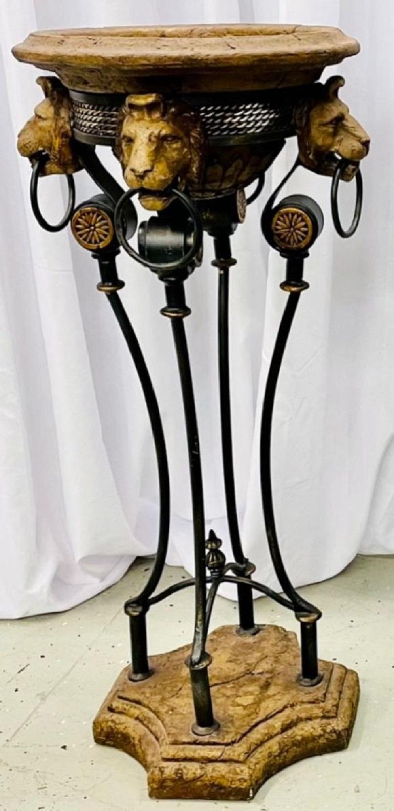 A Pair of Neoclassical Style Planters / Jardinières on Metal Stands. Each having four lions with rings in their mouths on a metal stand supported by an octagonal Antique base. The removable potted tops with hairy inserts. The pair having an aged