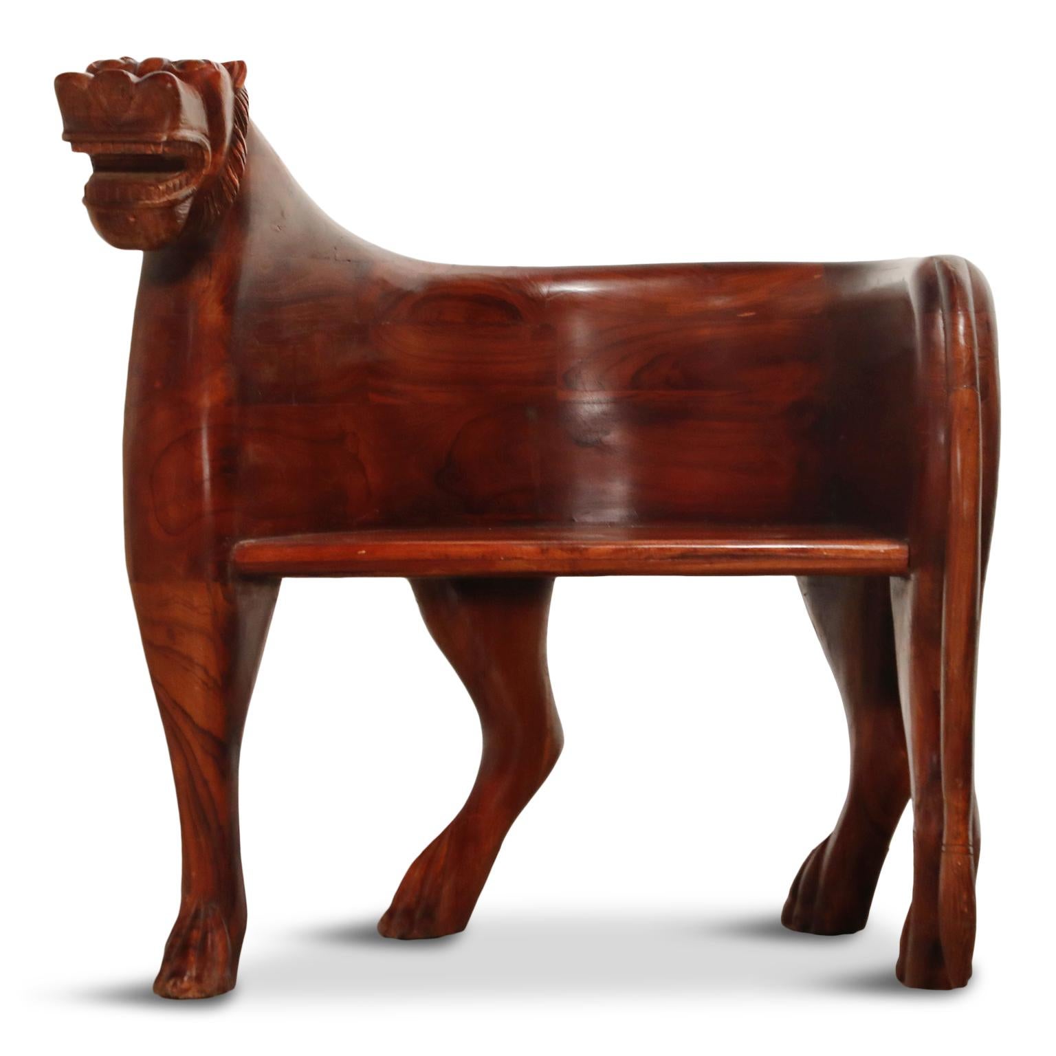 This spectacular pair of hand carved teak lioness club chairs are front-cover-magazine-worthy and can add a bit of the unexpected to any style of room. The color is a deep reddish brown that more closely resembles rosewood or Brazilian Jacaranda