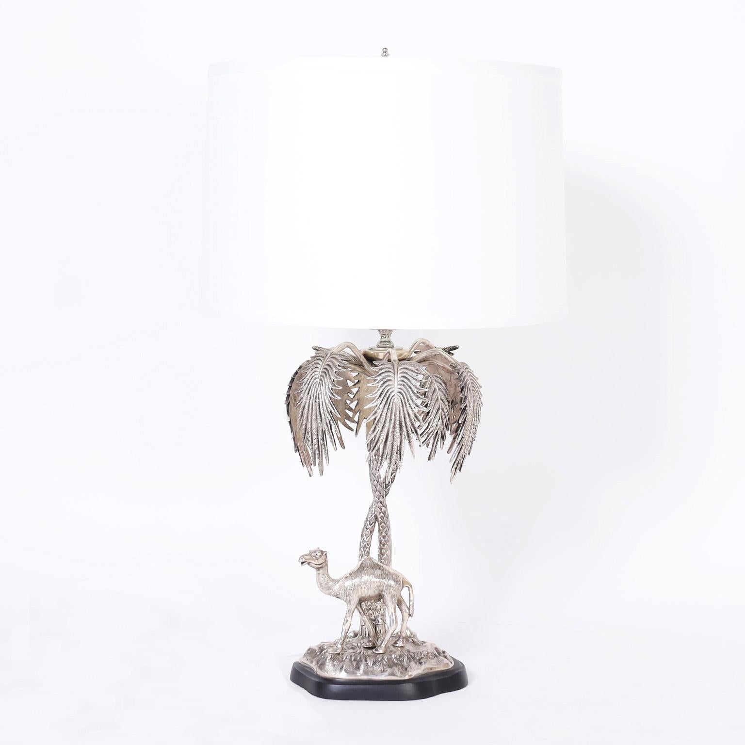 Pair of English table lamps crafted in silver plate over cast brass depicting a camel and an elephant under palm trees on terra firma bases.
