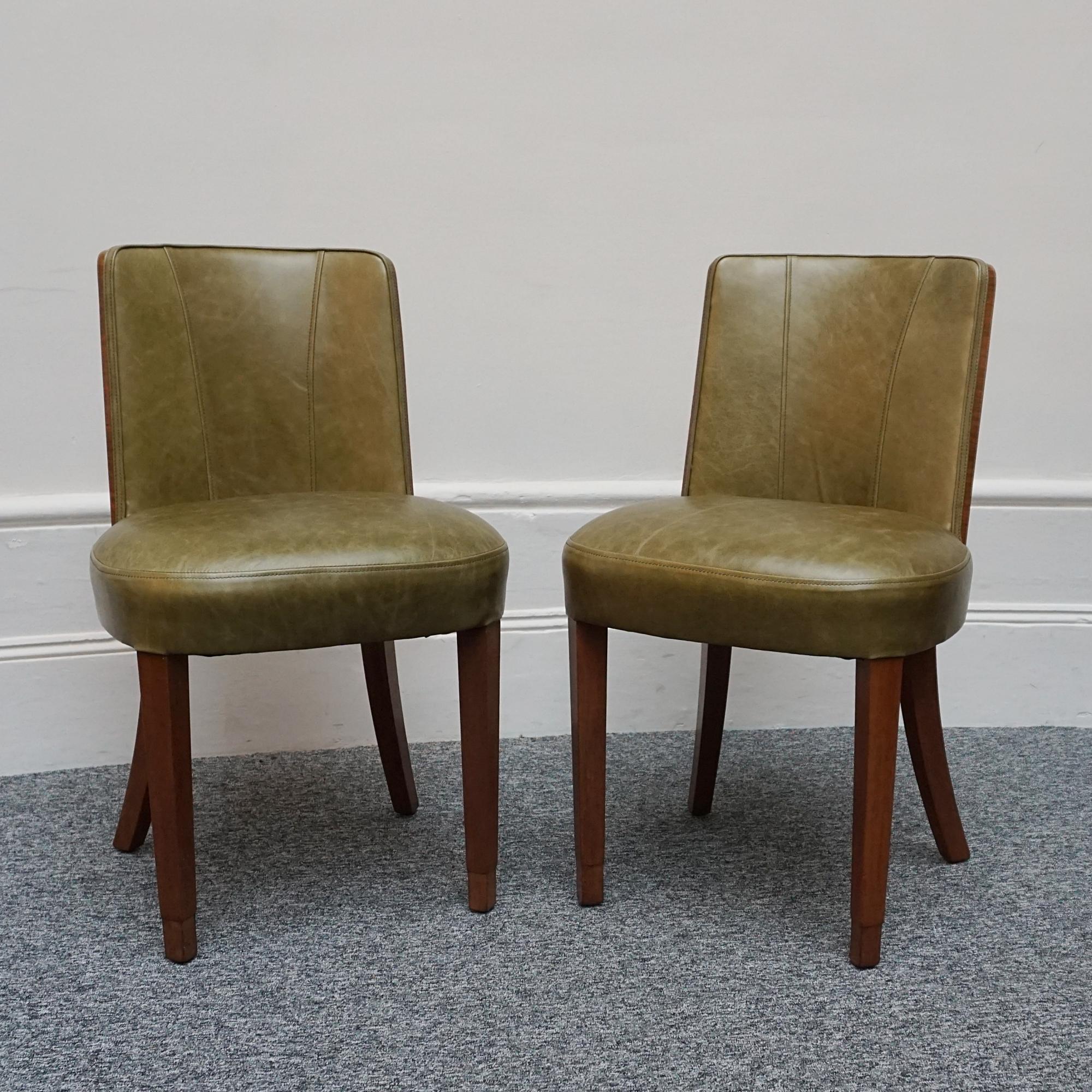 A pair of Art Deco side chairs. Contrasting figured walnut veneered backs with solid walnut legs. Re-upholstered in olive green leather. 

Two pairs available.

Dimensions: H 82cm W 49cm D 42cm Seat H 49cm 

Origin: English

Date: Circa 1935

Item