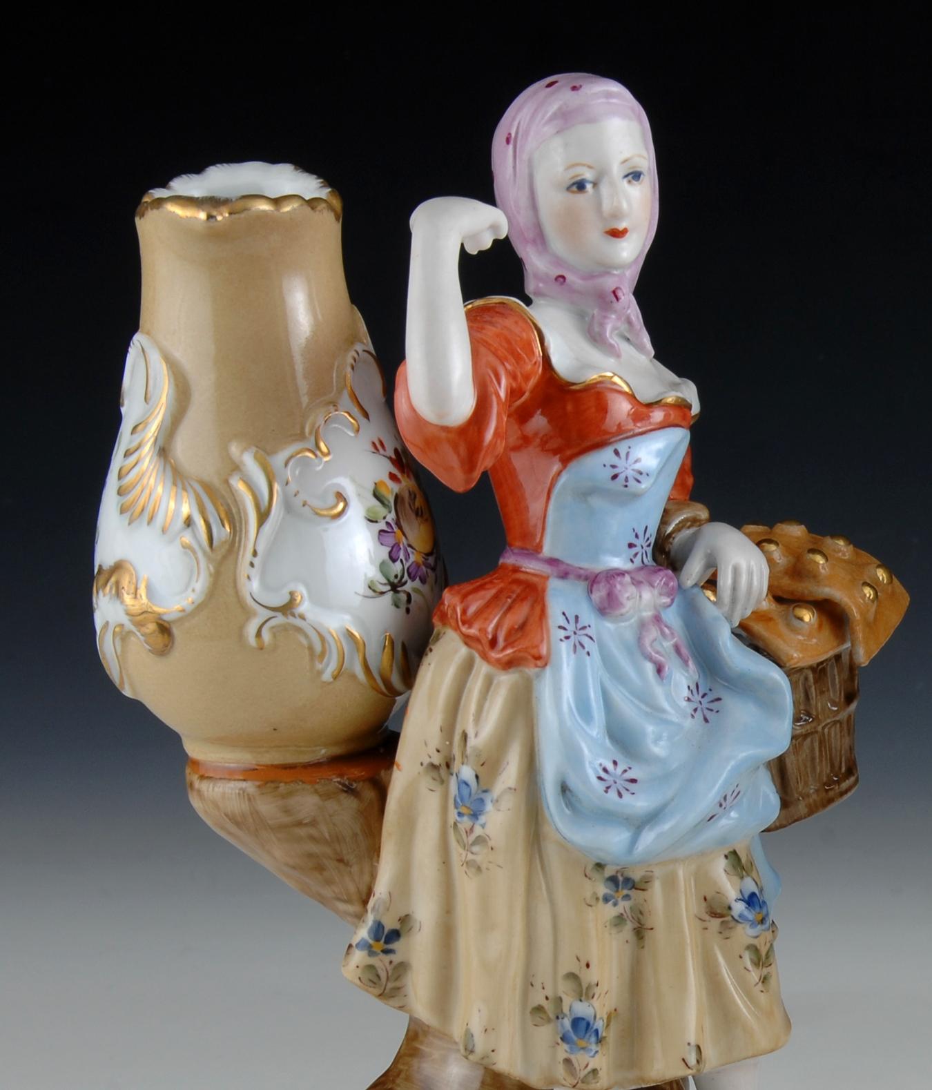 Couple of figures holding two vases, of the type used to contain a flower. Both the young man and the lady stand on round bases decorated with curved elements inspired by the Rococo. The influence of works of important European porcelain factories