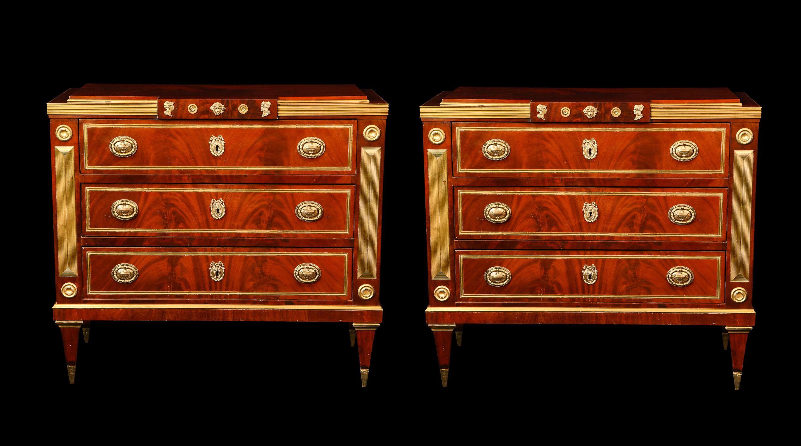 A pair of fine antique Russian neoclassical gilt bronze-mounted three-drawer mahogany commodes of superb detail embellished with neoclassical gilt bronze mounts.