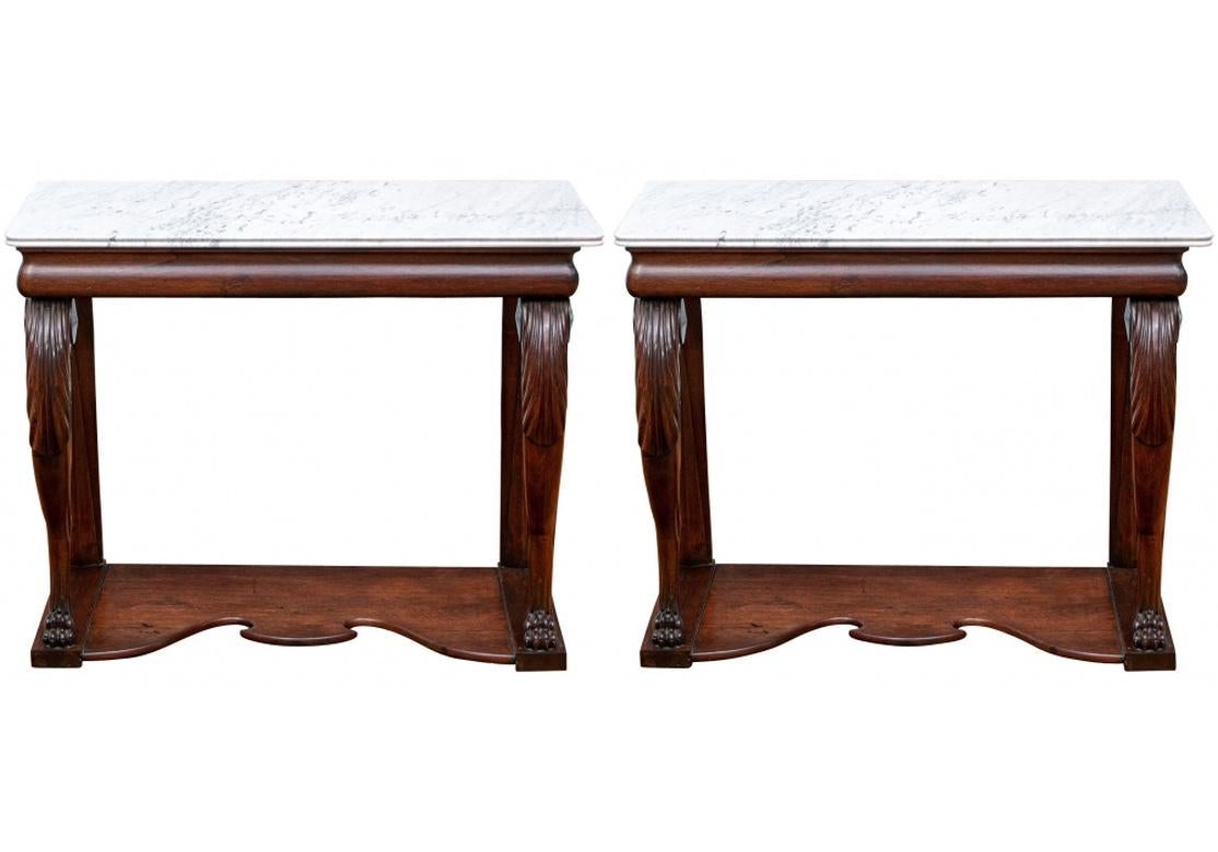 Rectangular tables with carved lion paw form front legs with large acanthus leaf details. The square back legs with carved vertical details. Shaped incurved bases. The white marble tops with carved edges.
Measures: L. 40 1/2