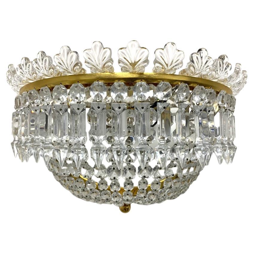 Deep demilune gilt bronze twin light sconces with the company stamp on the side of each frame. Marked Series No.5. The frames with demilune and knob terminals. The tops are set with crystal palmettes and pendant crystal prisms. Crystal chains with