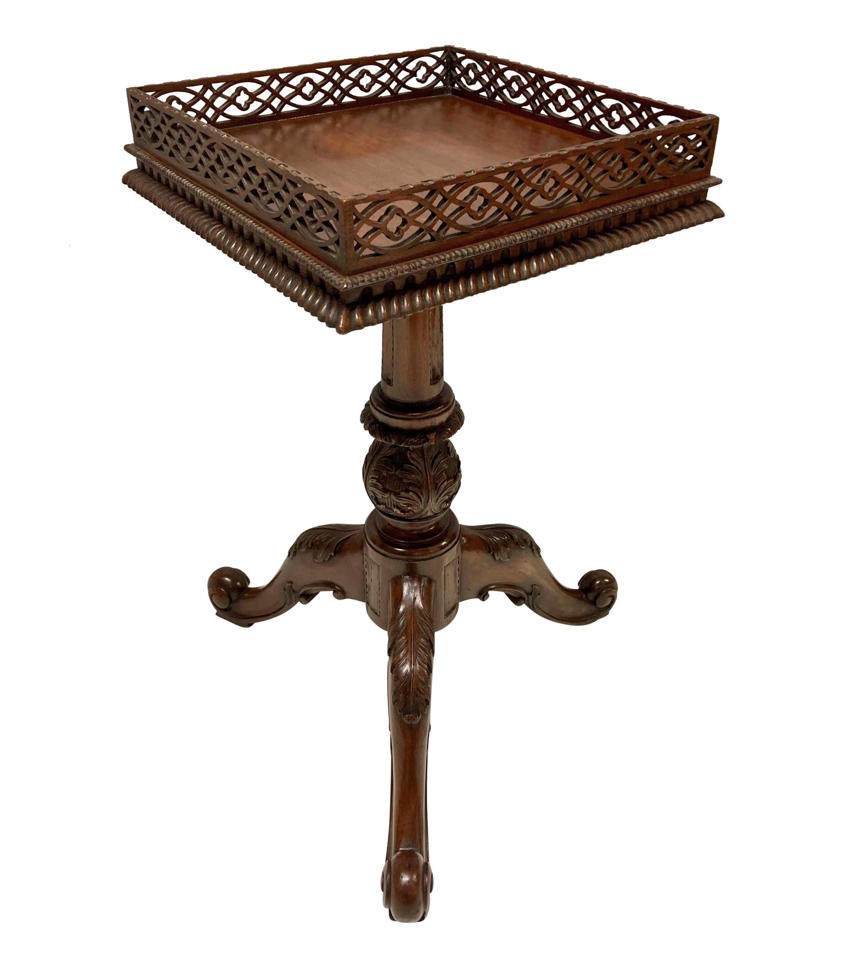 A fine pair of Chippendale style carved mahogany wine tables, on carved cabriole tripod bases with fretwork galleried tops.
