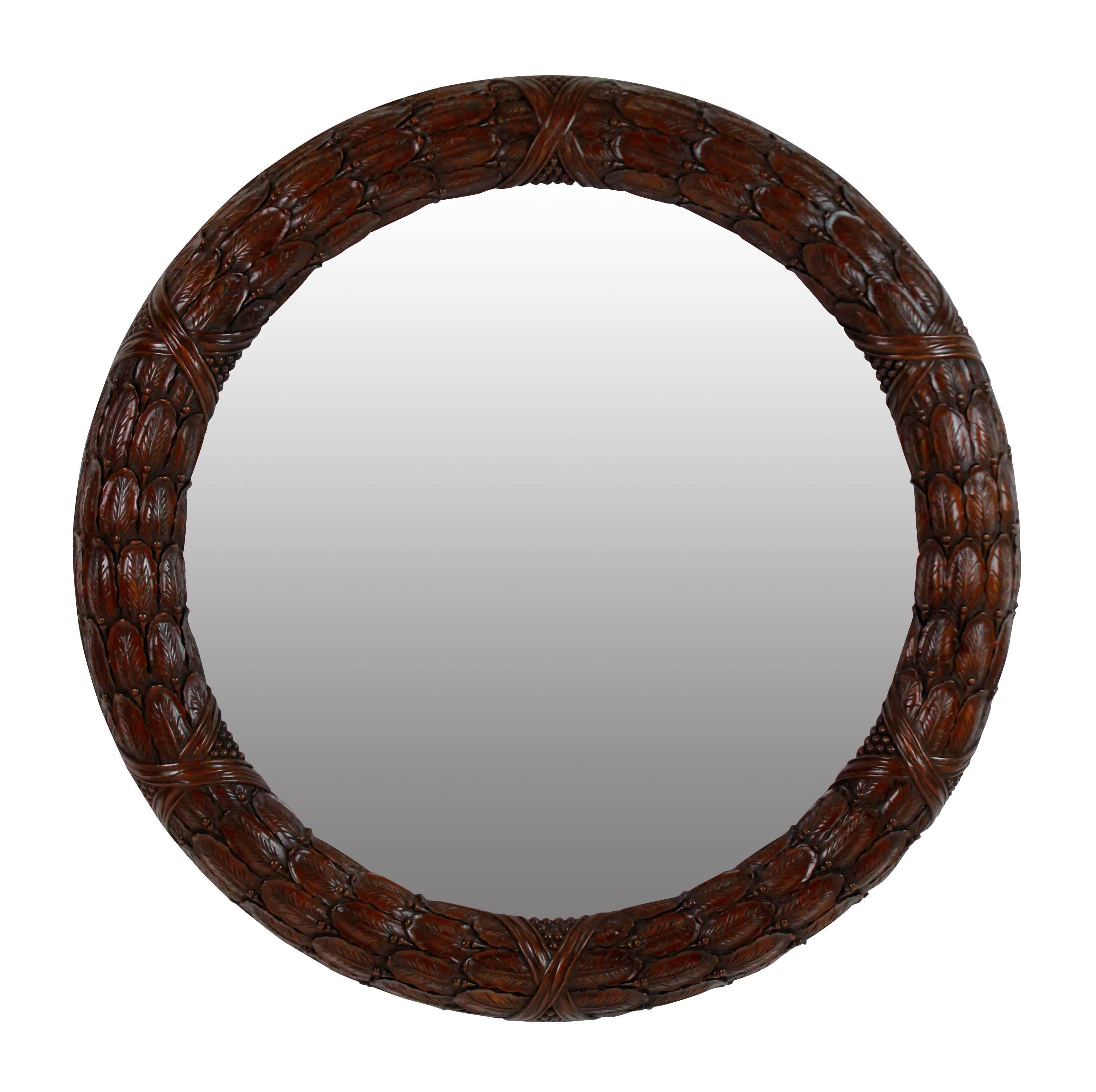 A pair of English finely carved mahogany laurel wreath circular mirrors with distressed mirror plates.
 