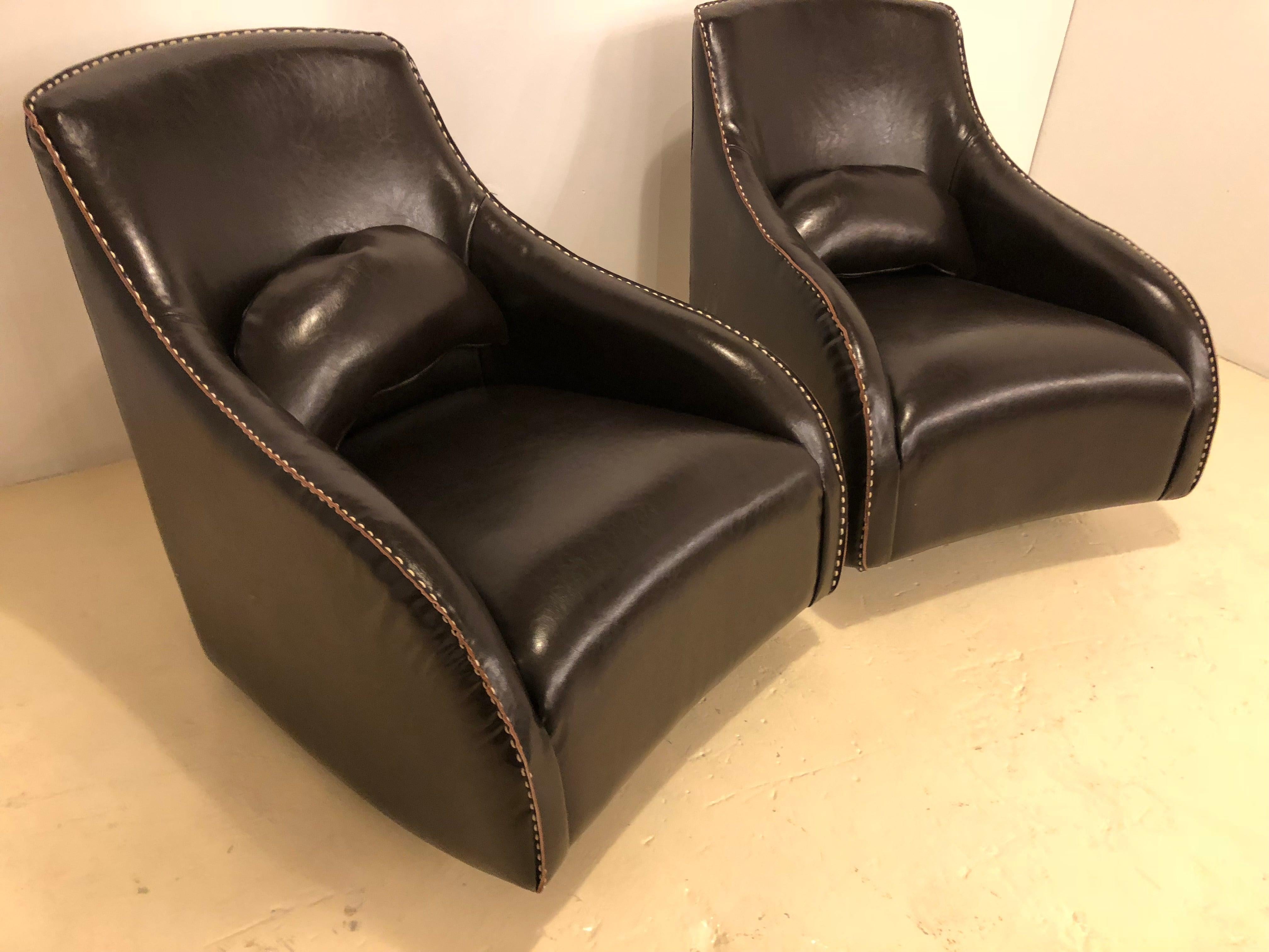 A timeless pair of fine leather rocking club chairs in the Mid-Century Modern style. Each chair is handstitched and features a dark brown color that will fit in any living space. The chairs are as much as very comfortable as stylish.