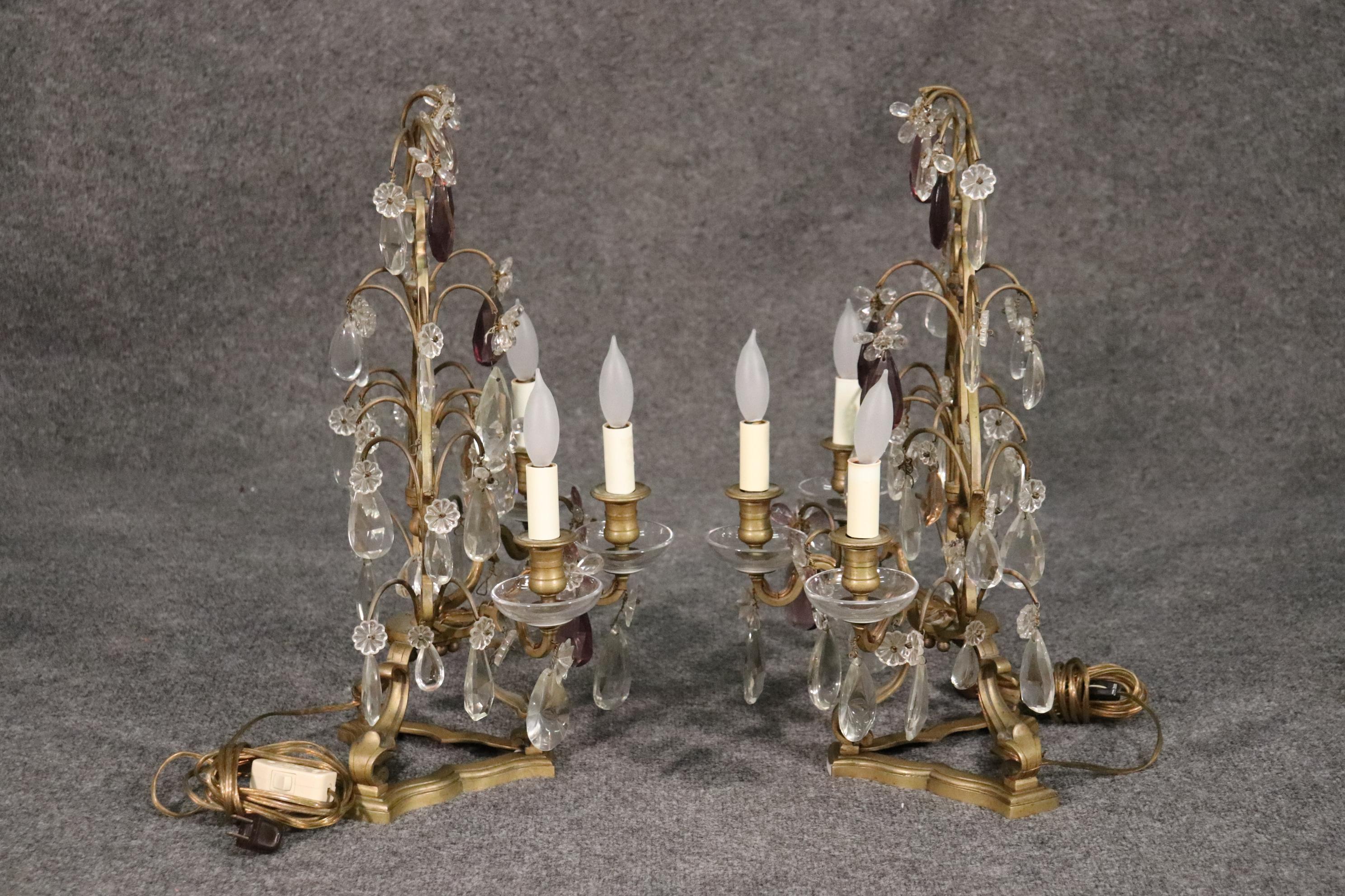 This is a fine pair of vintage 1940s French tabletop candelabrum, circa 1940. They are fitted with fine clear crystals and amythest colored crystals. Measures 22 tall x 14 wide x 9 deep.