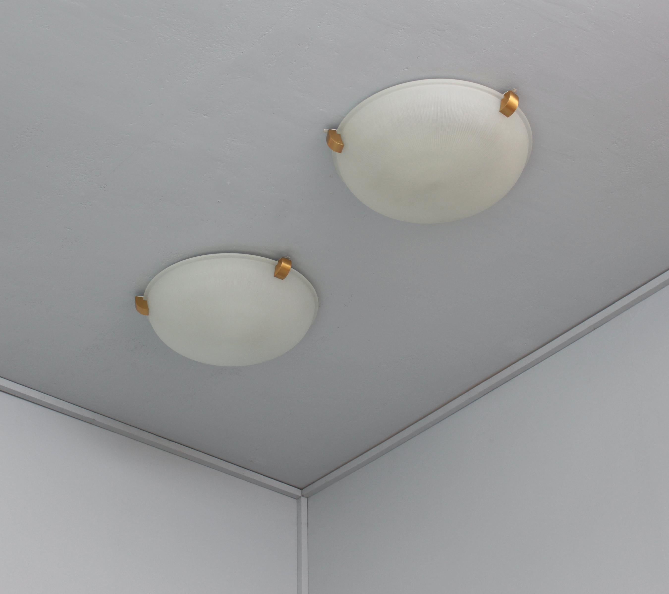 Atelier Perzel - A pair of fine French Art Deco ceiling or wall lights with a round optical fluted frosted glass shade supported by three bronze studs.
Price includes UL listing re-wiring.
          