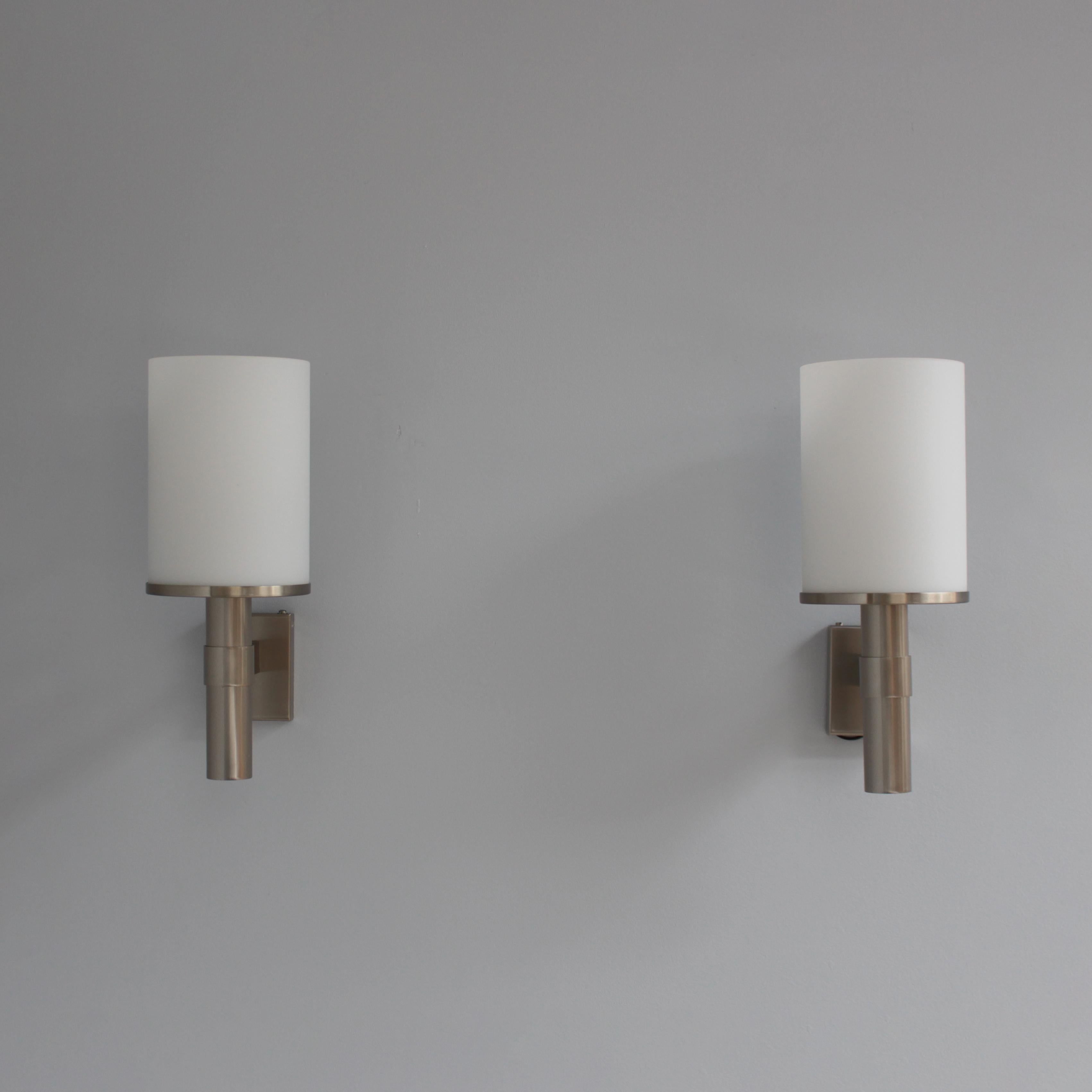 Atelier Perzel - A pair of fine French Art Deco wall lights with a nickel base and an enameled glass cylinder shade.
