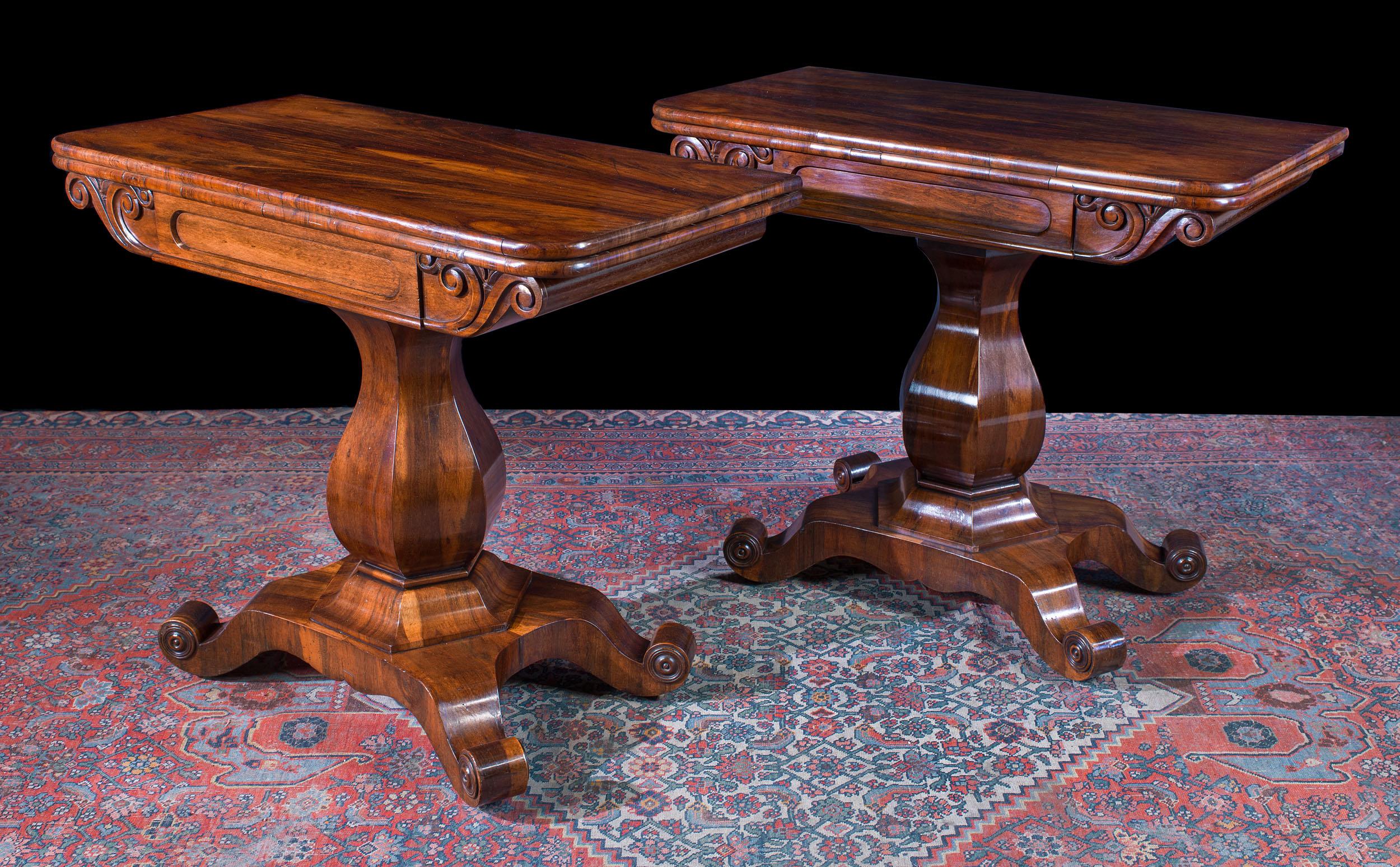 A pair of William IV tea tables, with book matched veneered tops in the rare Goncalo Alves, or Brazilian tiger wood, the mirror image of the other. The folding tops are mounted on sweeping hexagonal baluster supports, over swept feet. The tables are