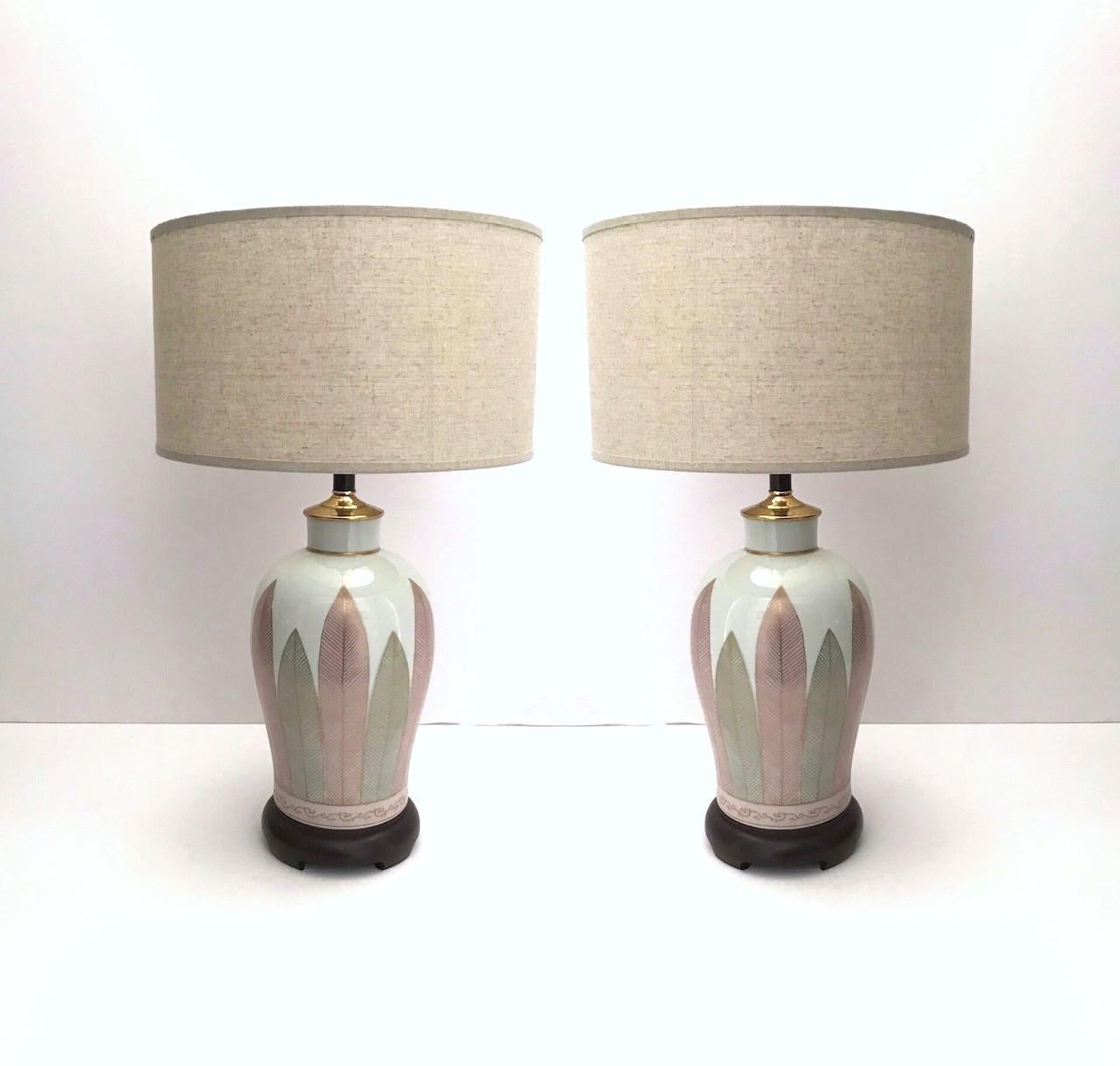 Exquisite pair of Mid-Century Modern Japanese porcelain lamps with white crackle glaze finish. Lamps have elegant urn forms with hand painted leaves in alternating hues of pink and grey, and outlined in 22-karat gold leaf. The hand-applied gold is