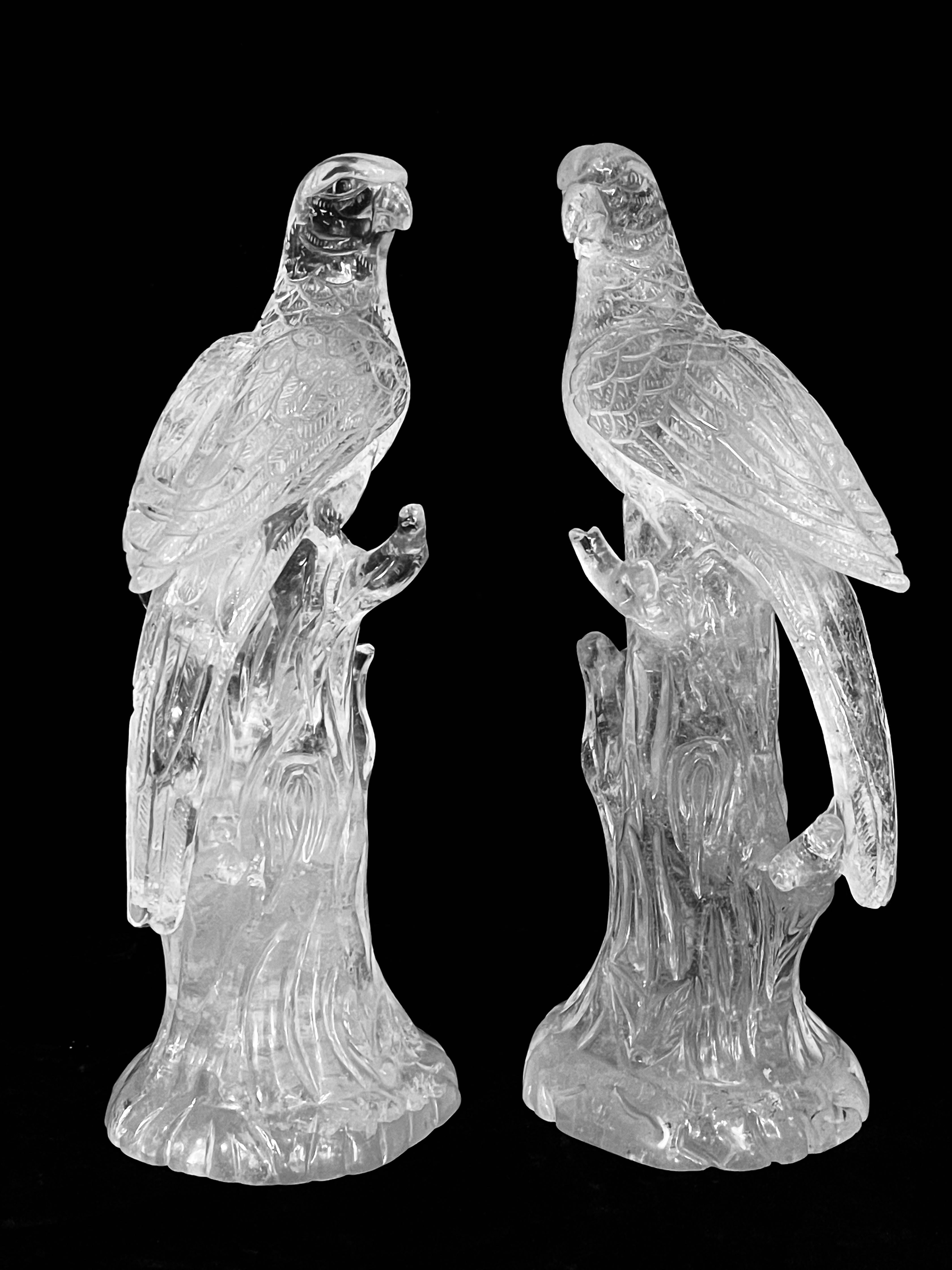 Pair of exquisite and extremely rare hand carved rock crystal parrots. Each sculpture is masterfully executed from a single piece of clear rock crystal, showcasing exceptional clarity with delicate natural inclusions that enhance the luminous