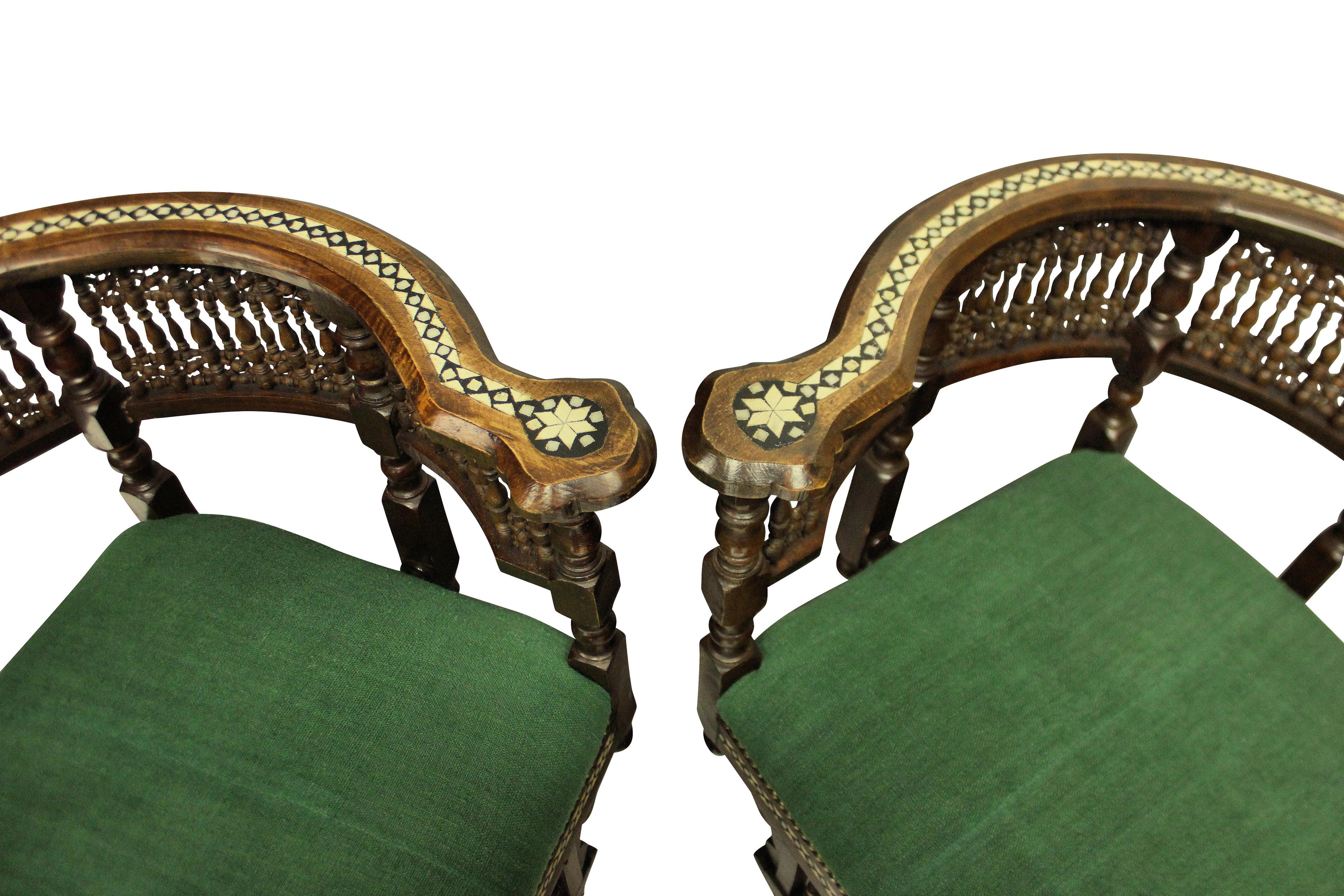 A pair of finely carved Moorish corner armchairs in hardwood and inlaid with bone and ebony. Newly upholstered in 19th century green French linen.