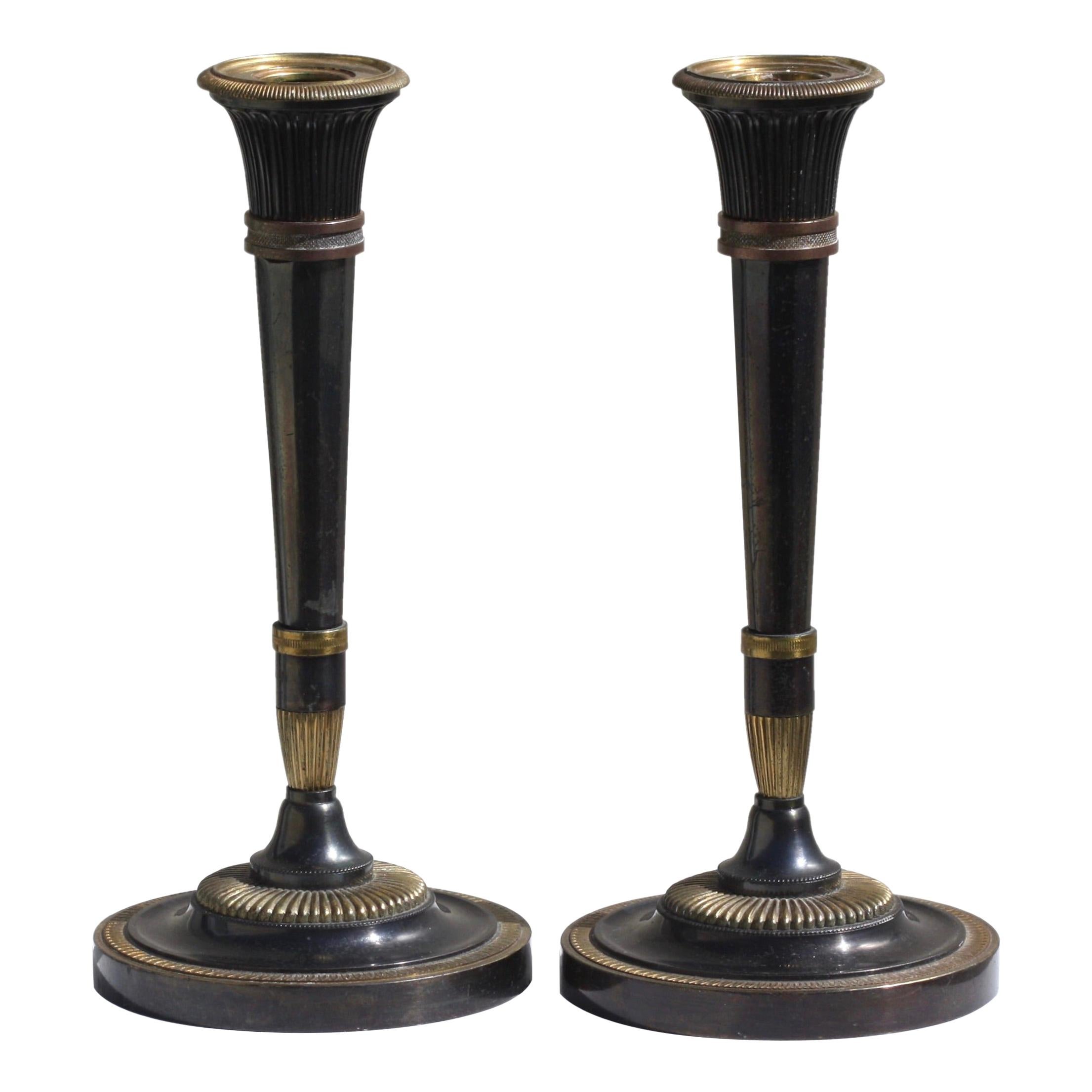 Pair of Fine Neoclassical Parcel Gilt Polished Steel Candlesticks For Sale