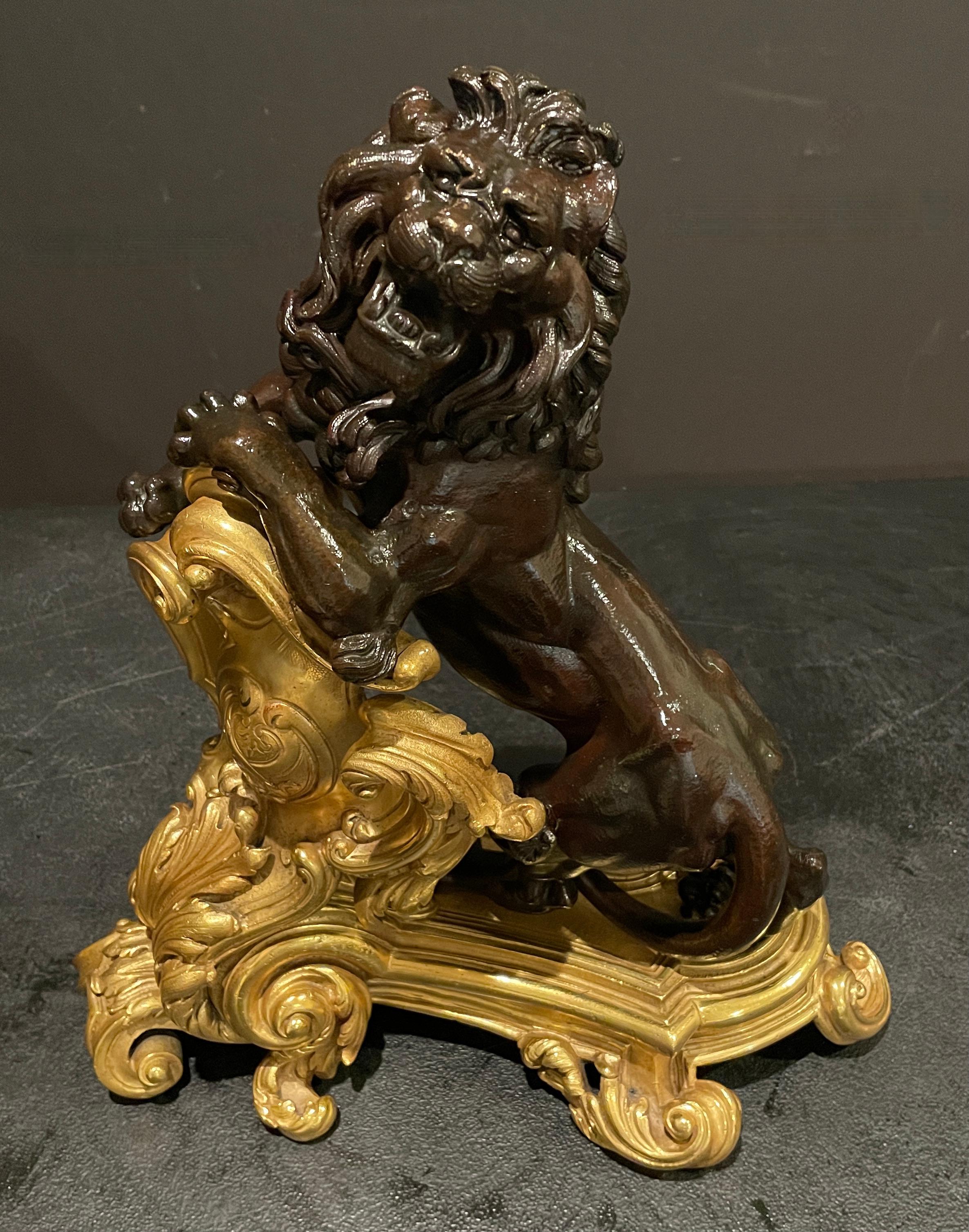 Pair of gilt and patinated figural lion form 19th century French chenets. In the Rococo style, with full figure lions. Finely sculpted raised lions resting on Rococo shield flowing into footed plinth.