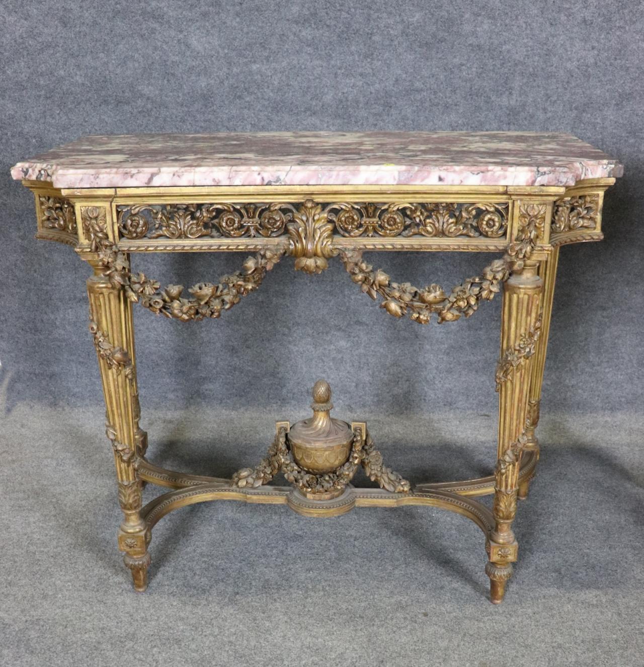 Presenting an exceptional pair of French Louis XVI giltwood console tables featuring exquisite Brèche Violette marble tops, an outstanding example of late 19th-century craftsmanship and architectural refinement. Measuring 36 1/4