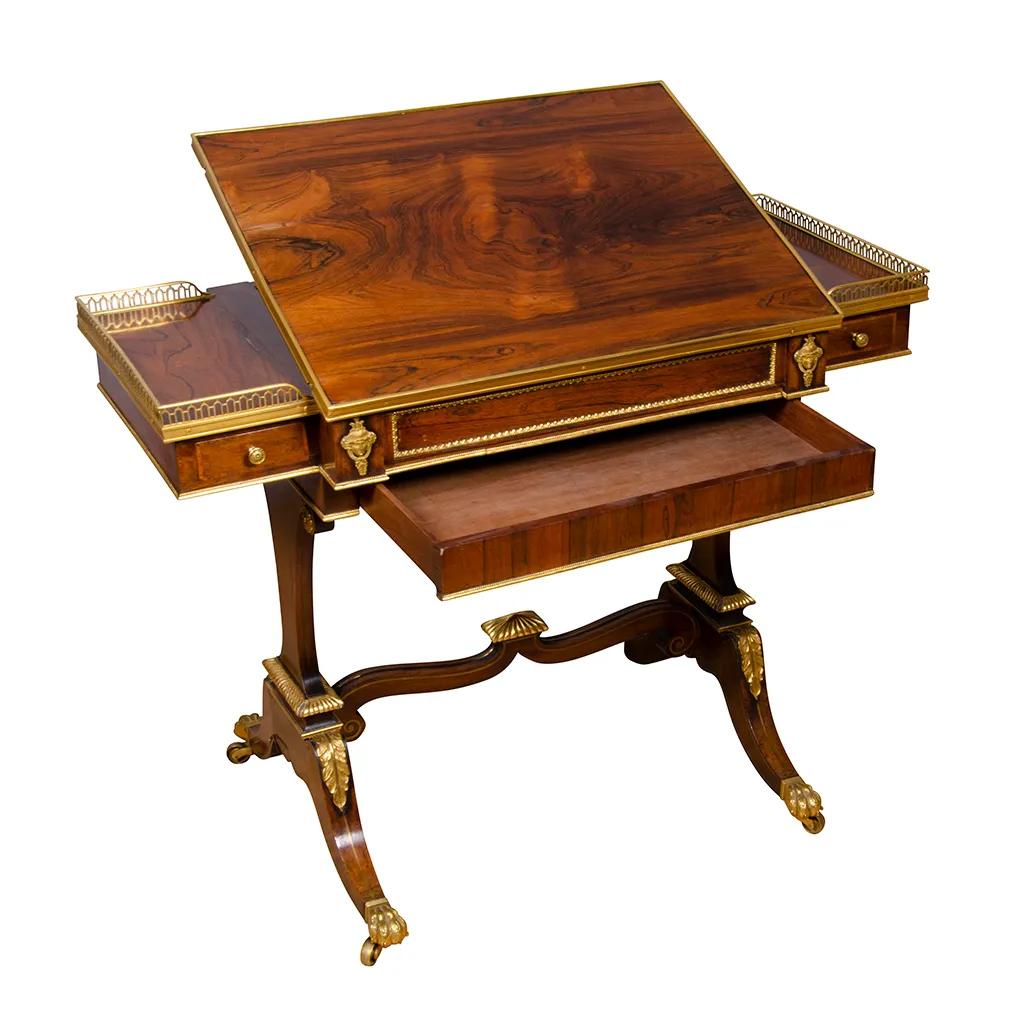 Fine pair of Regency Rosewood and Bronze Mounted Writing / Games Table rectangular with bronze gallery and ratcheted writing surface over a frieze containing drawers and a game board, raised on a trestle base with saber legs mounted with leaf form