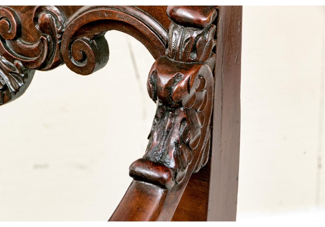 Paire de chaises d'appoint à l'assise en velours brun. Le dossier est orné d'une coquille sculptée flanquée de C.I.C. en relief. Les chaises sont dotées d'accoudoirs sur toute la longueur se terminant par une grande volute sculptée. Les chaises