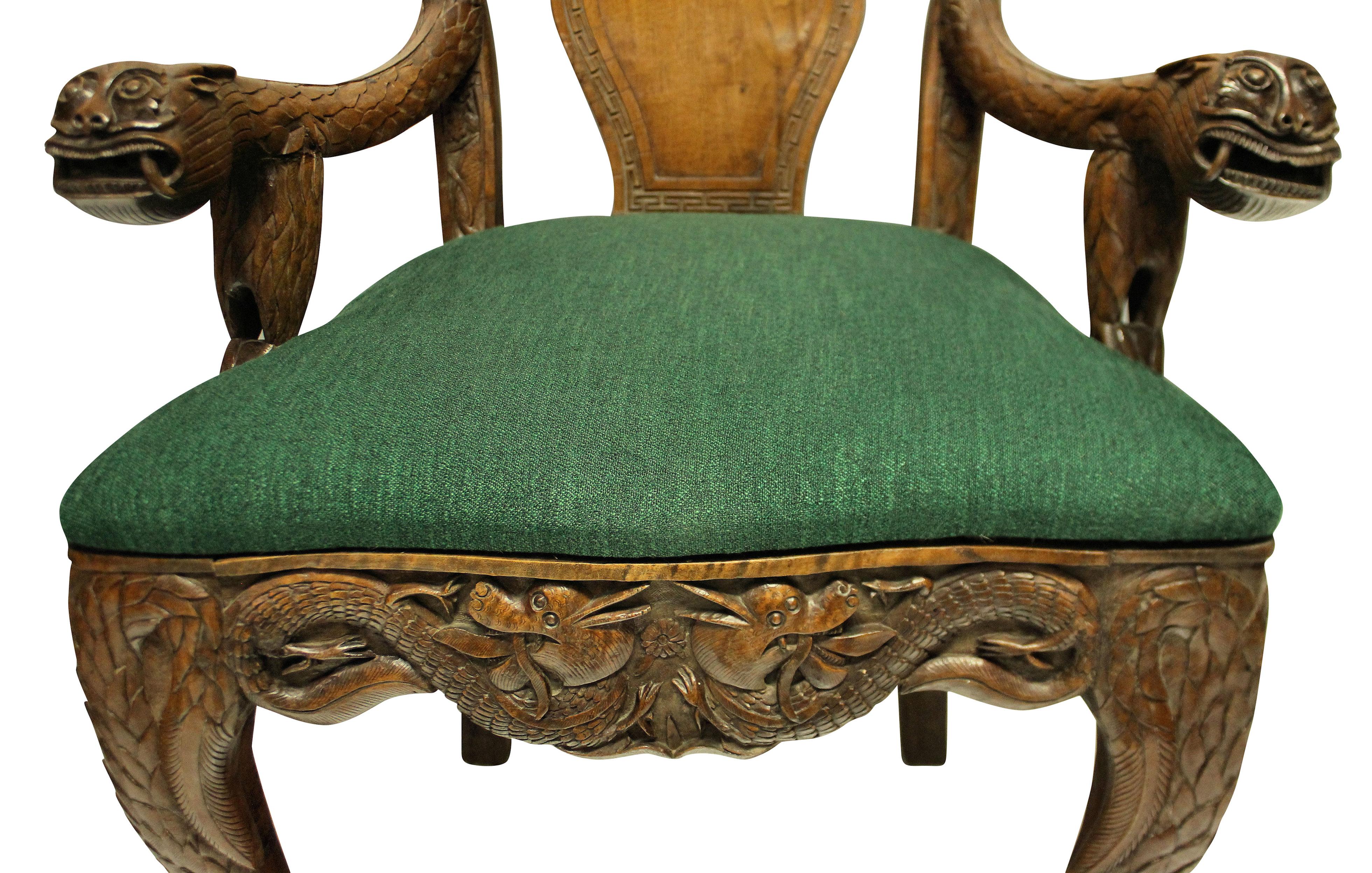 A pair of finely carved, highly decorative Chinese armchairs in solid teak. The chairs are full of symbolism and meaning, with lions, dragons, bats, lotus flowers and symbols. With seats newly upholstered in emerald green.