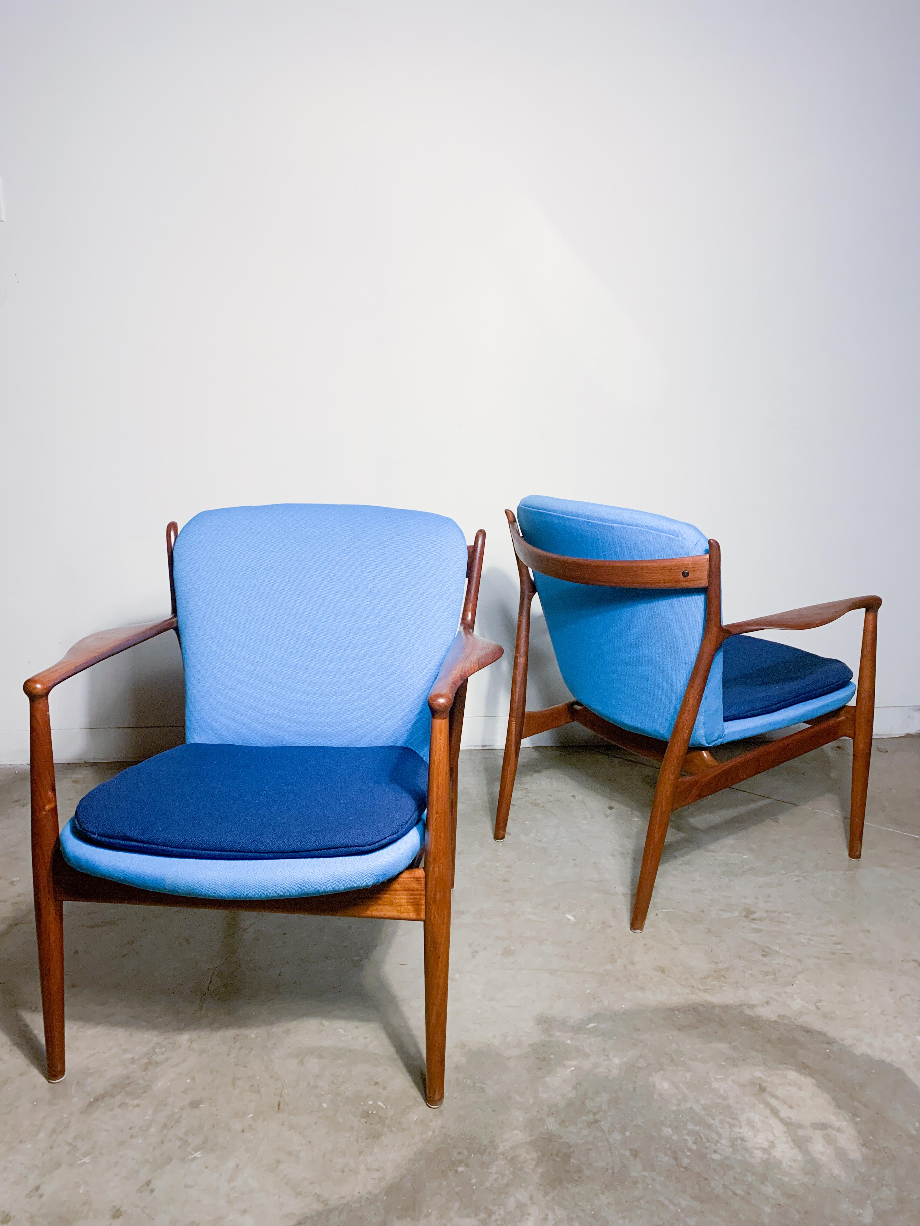 Beautiful and rare solid walnut armchairs designed by Finn Juhl as part of his 1951 Modern collection of Baker Furniture. Expertly sculpted frames of organic forms and stunning woodgrain. Two tone upholstery and new foam in great condition.