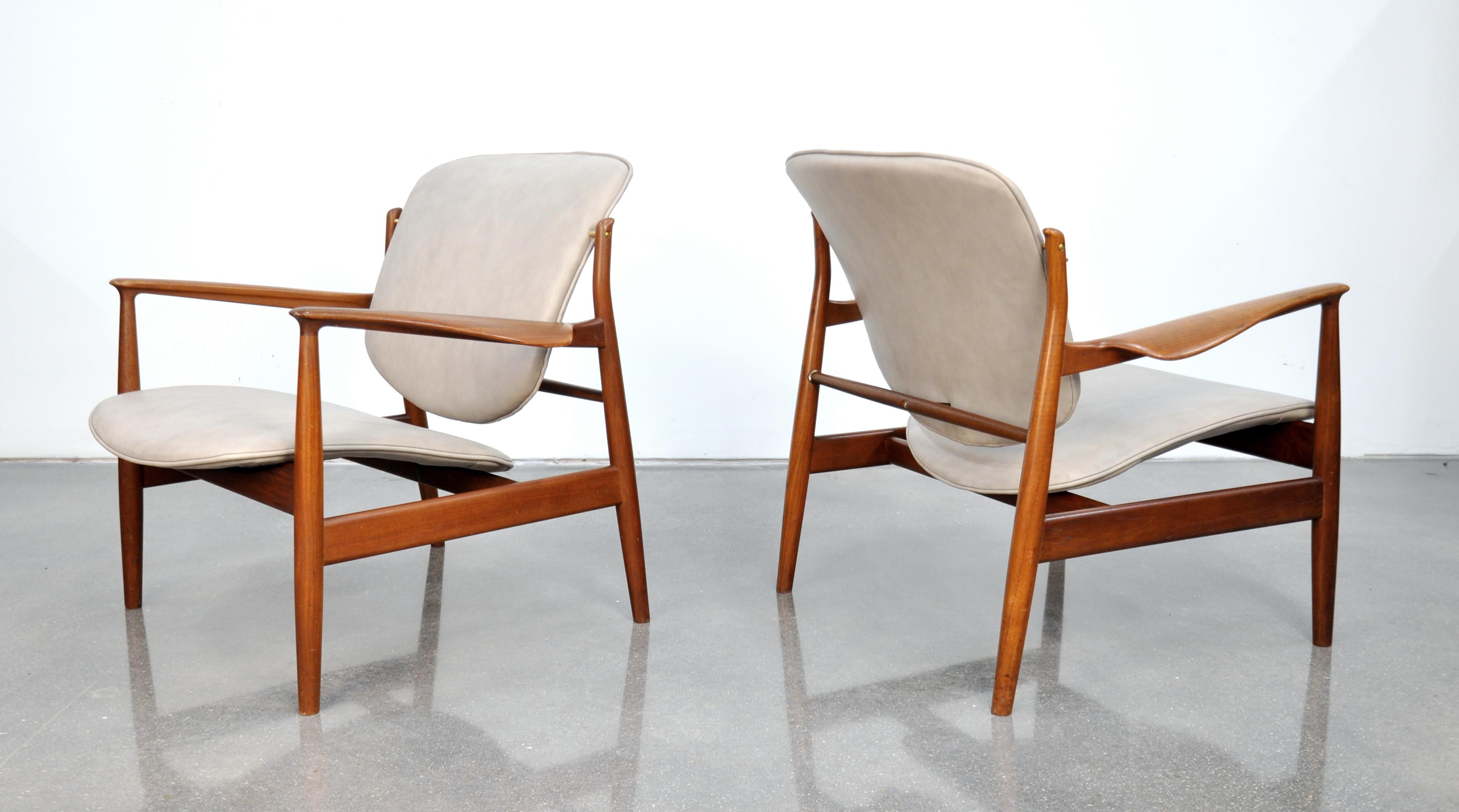 Pair of the iconic midcentury Danish modern easy chairs designed by Finn Juhl for France and Daverkosen (later named France and Son) in the 1950s. The splendidly sculpted teak frames are in original condition with amazing patina. The seats and