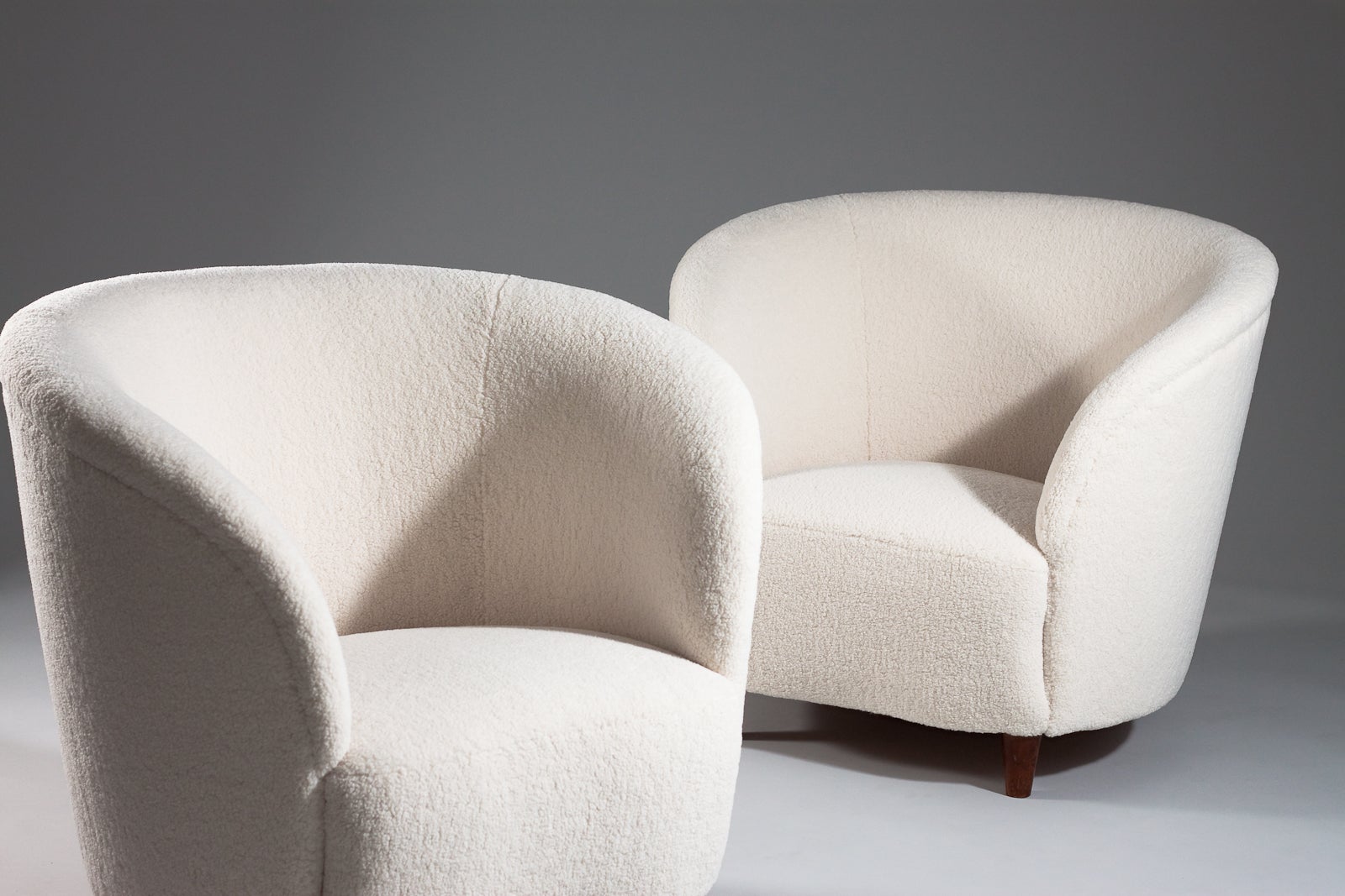 This rare pair of Scandinavian Modern lounge chairs are upholstered in a sheepskin-like quality fabric. The lounge chairs are in a perfect Size and manner to be included in any high-end interior design. The chairs have not been used after