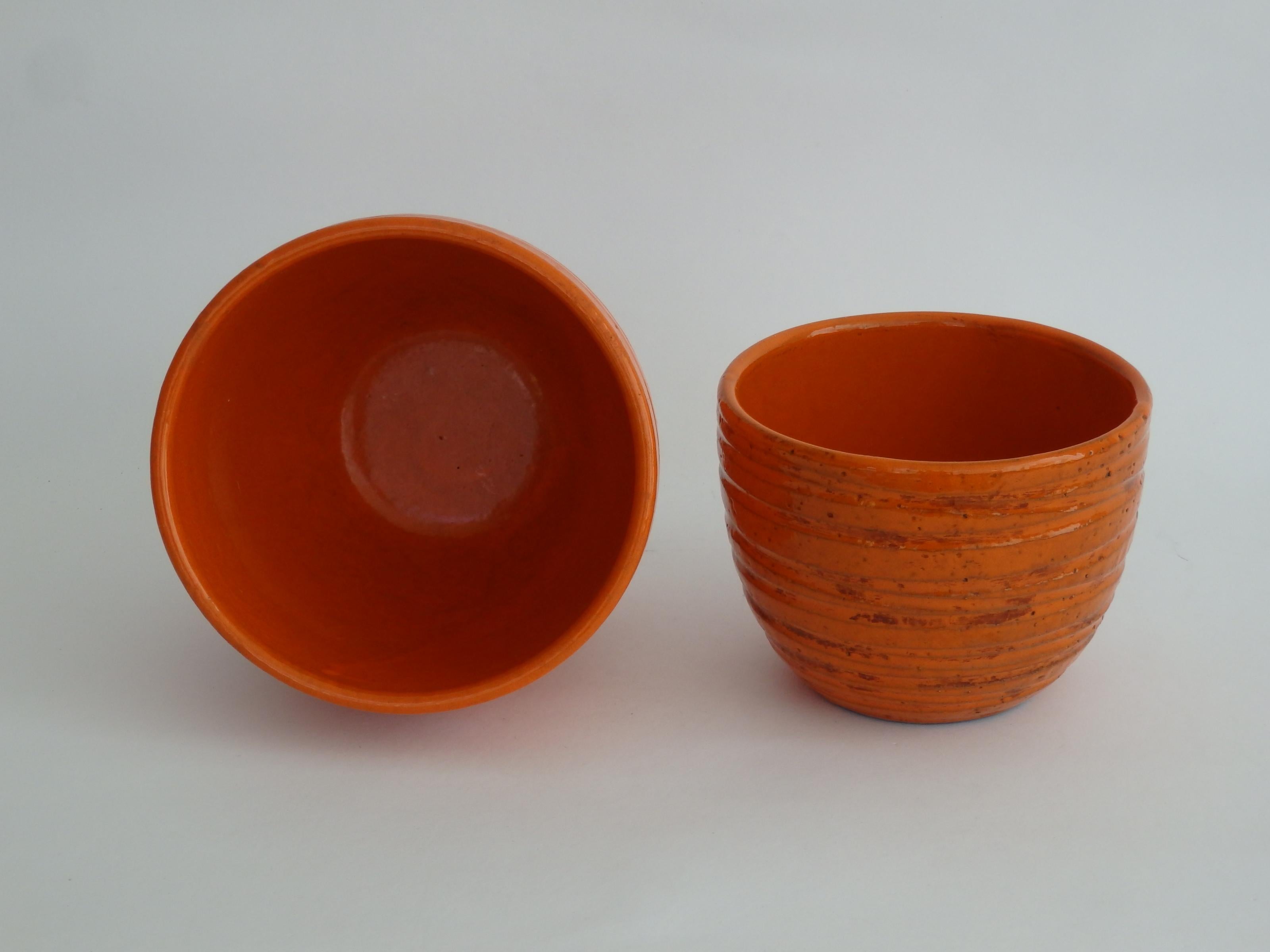 Pair of fire orange ribbed planter pots from Bitossi's Pietra (Stone) decor series. Attributed to Aldo Londi, by way of Rosenthal Netter. Paper labels intact on undersides.
Smaller pot measures: 4.5