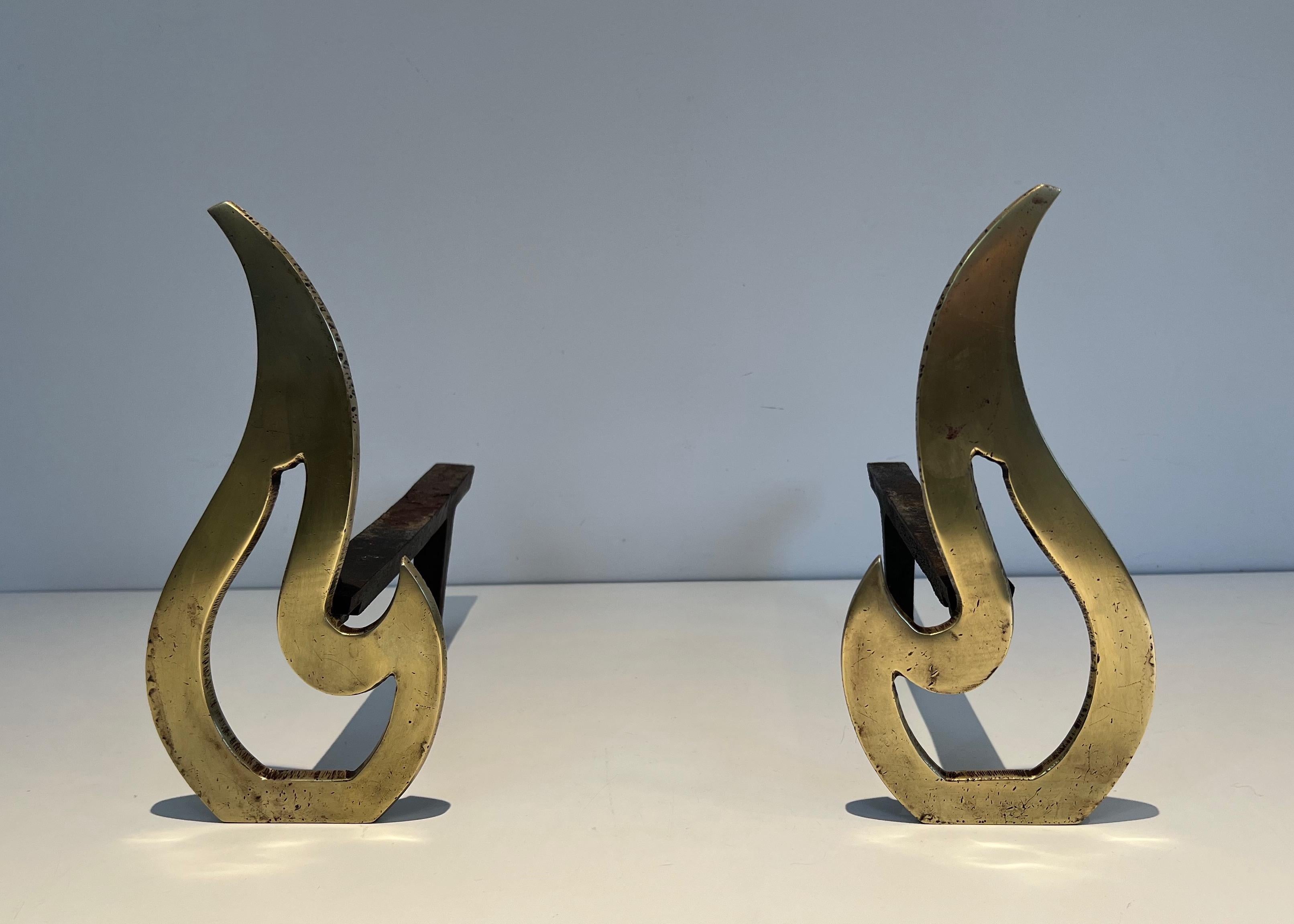 This pair of neoclassical style flame andirons is made of brass and iron. This is a Frenchw work, circa 1920.