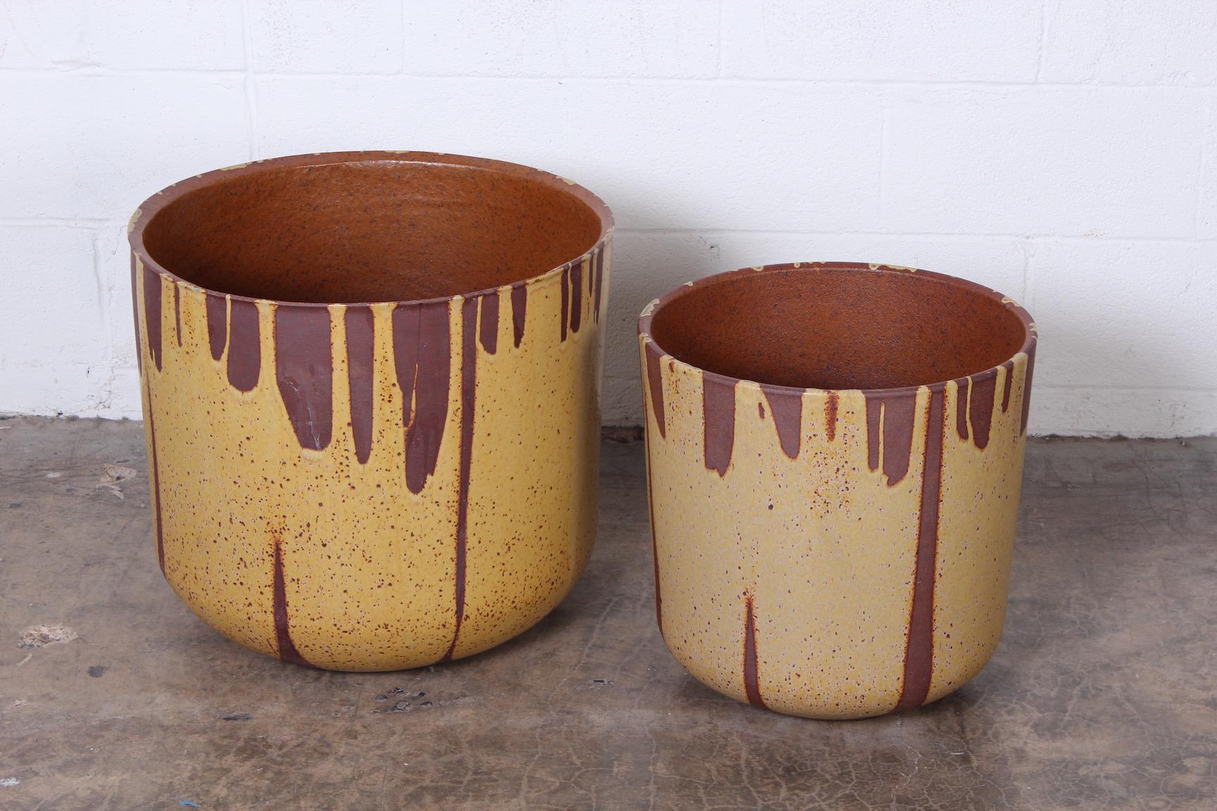 A pair of yellow flame glazed planters by David Cressey. 
Measures: Large 21 diameter x 18.75 height
Small 16.25 diameter x 16.5 height.
 