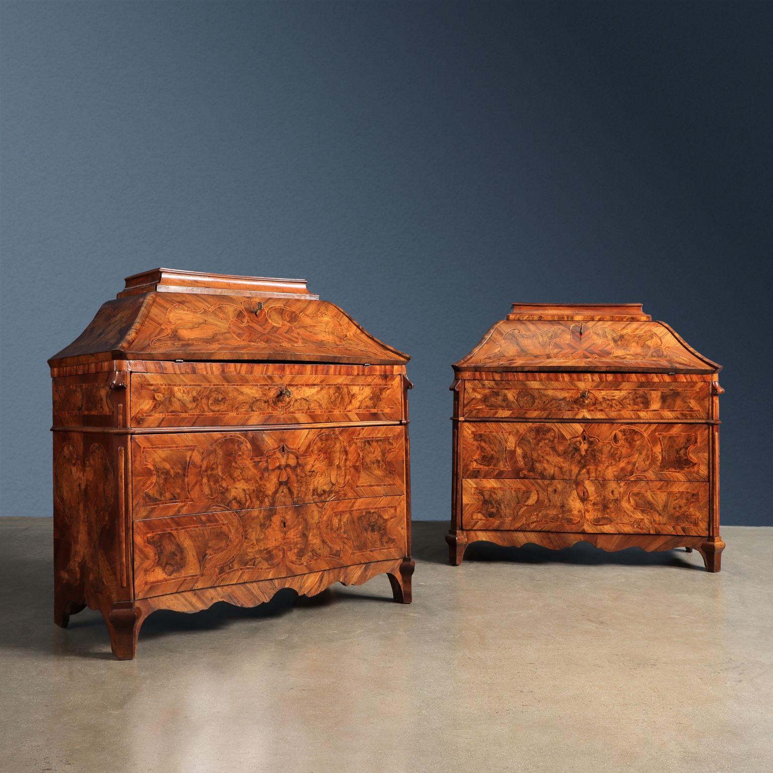 Pair of flaps slightly moved like a leaf on the front where three drawers are housed; the furniture continues in the upper part moving like an urn and ending in a backsplash with a removable drawer. The flap door conceals a cabinet made up of four