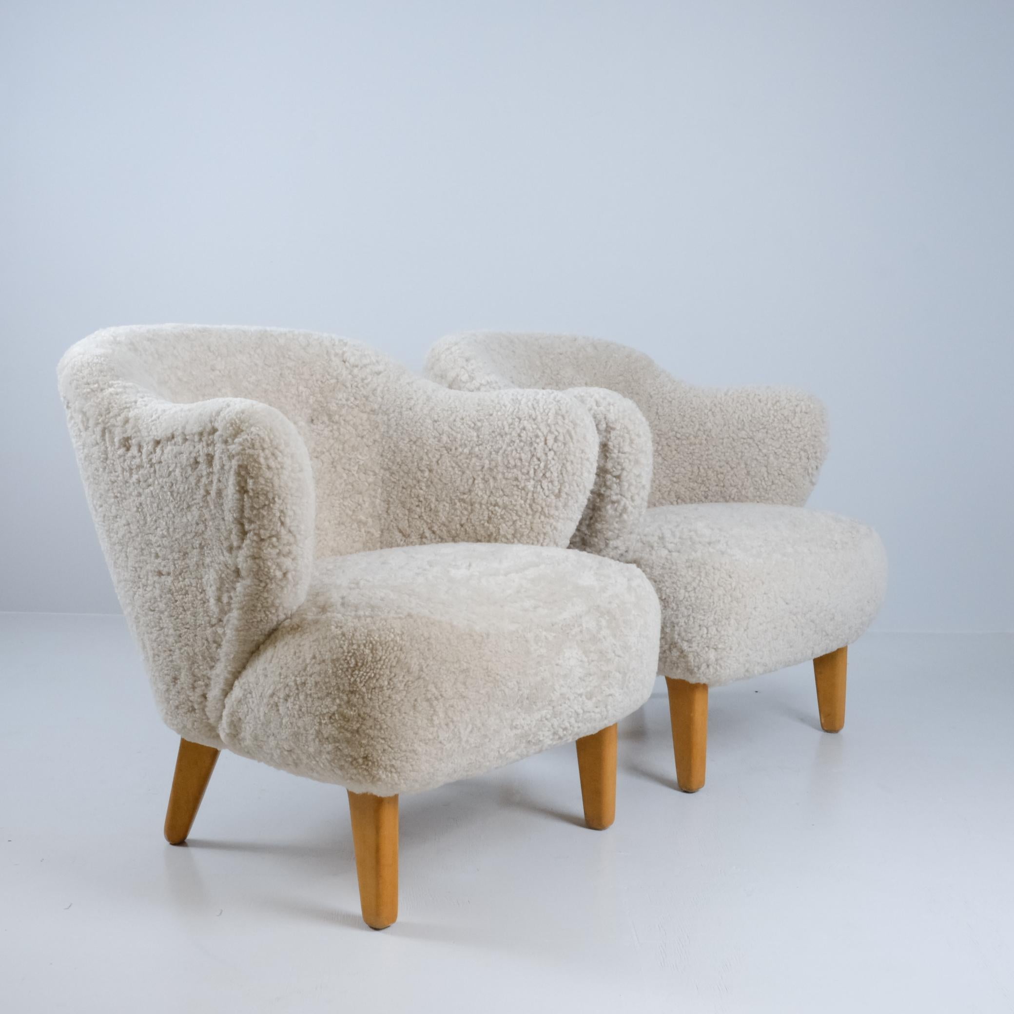 Preciosa pareja de sillones Ingeborg, del arquitecto danés Flemming Lassen, en suave piel de oveja natural beige. 

Los reposabrazos curvados y el respaldo abotonado ligeramente redondeado dan a las sillas una forma moderna distintiva. Eso,