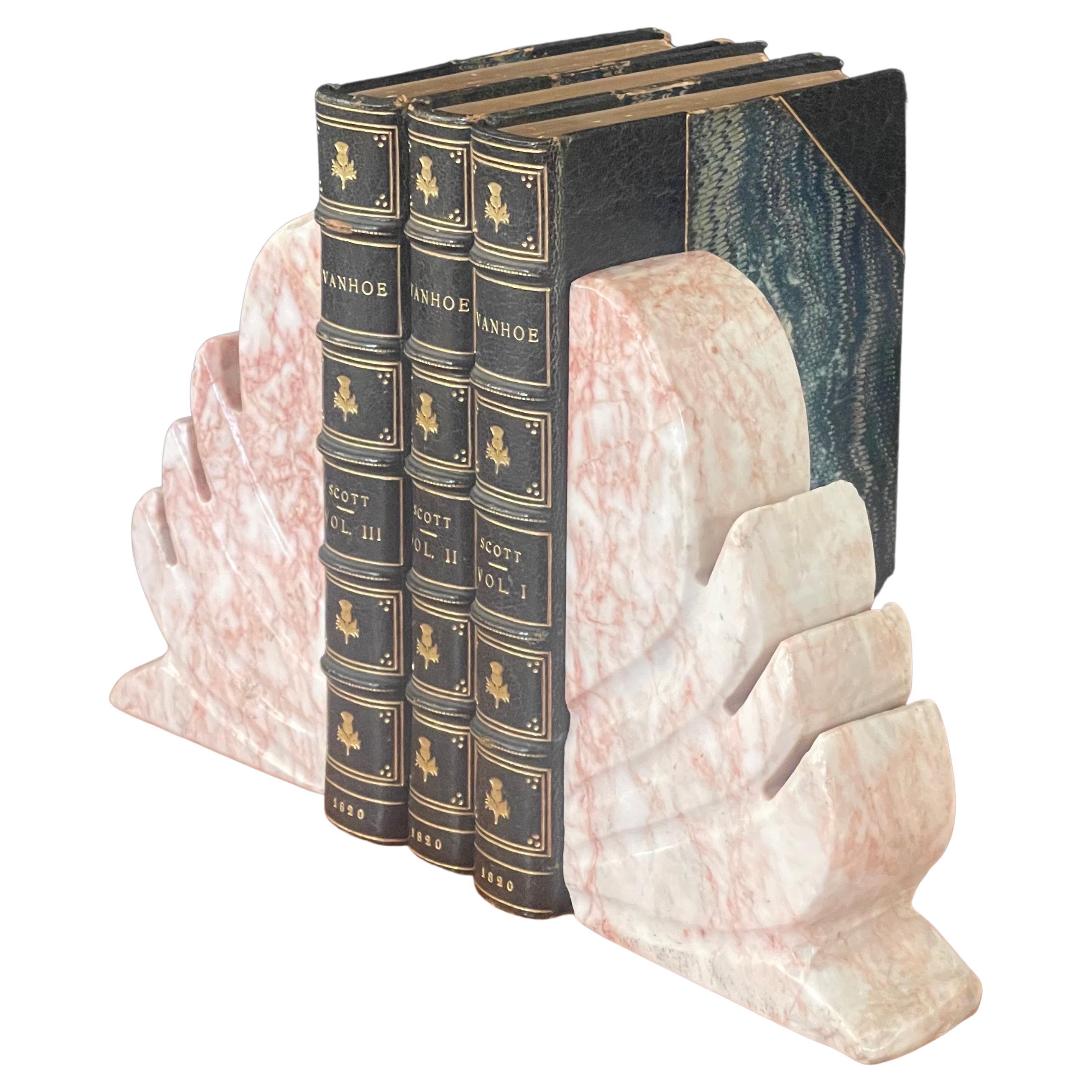 Paire de serre-livres en marbre de style fleur de lis, vers les années 1940. Les serre-livres sont lourds, solides et bien fabriqués. Ils mesurent 8 