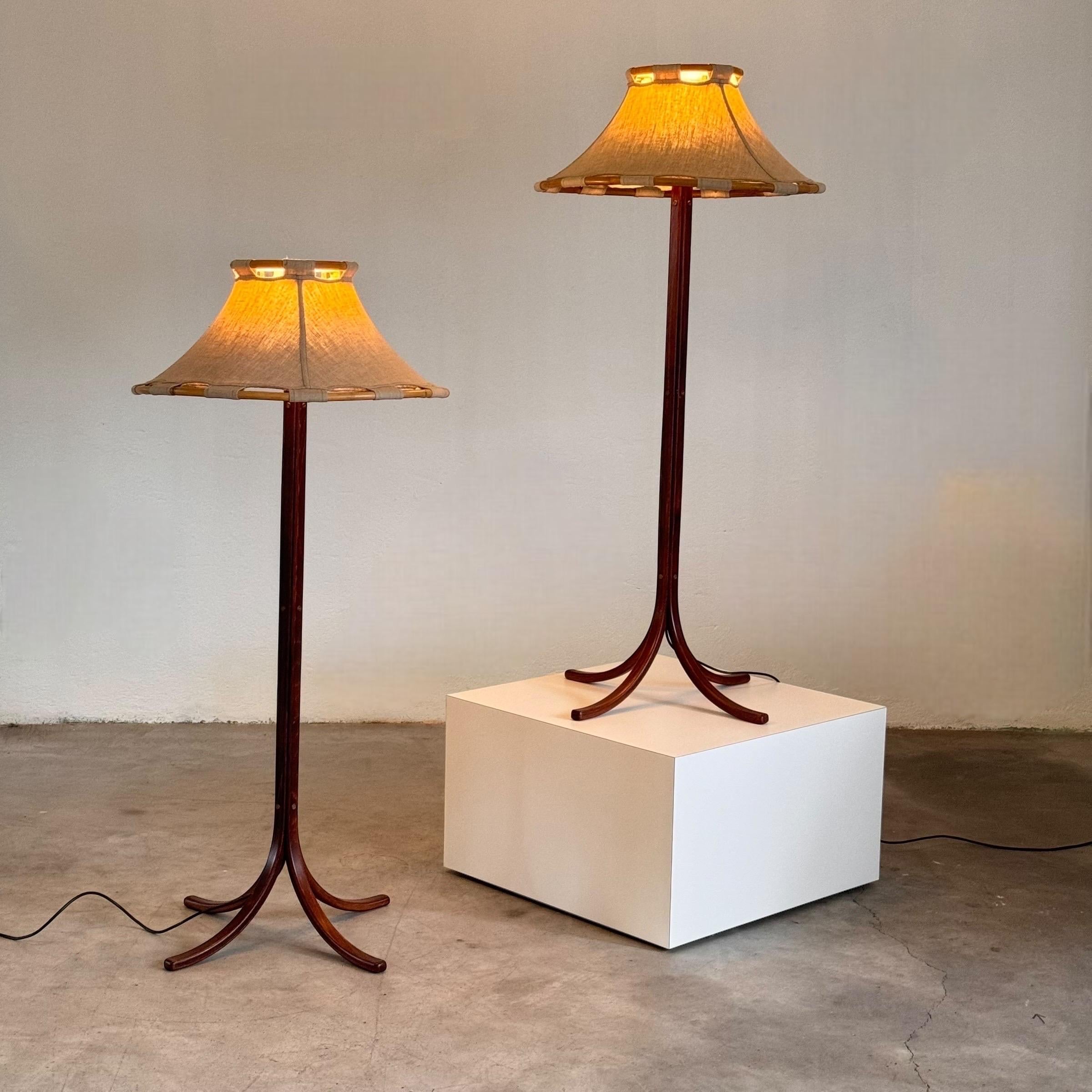 Discover the timeless elegance of this pair of floor lamps designed by Anna Ehrner for Atelje Lyktan, crafted in Sweden during the 1970s. These lamps showcase a perfect blend of dark oak wood, canvas fabric, bamboo, brass and plastic, exemplifying